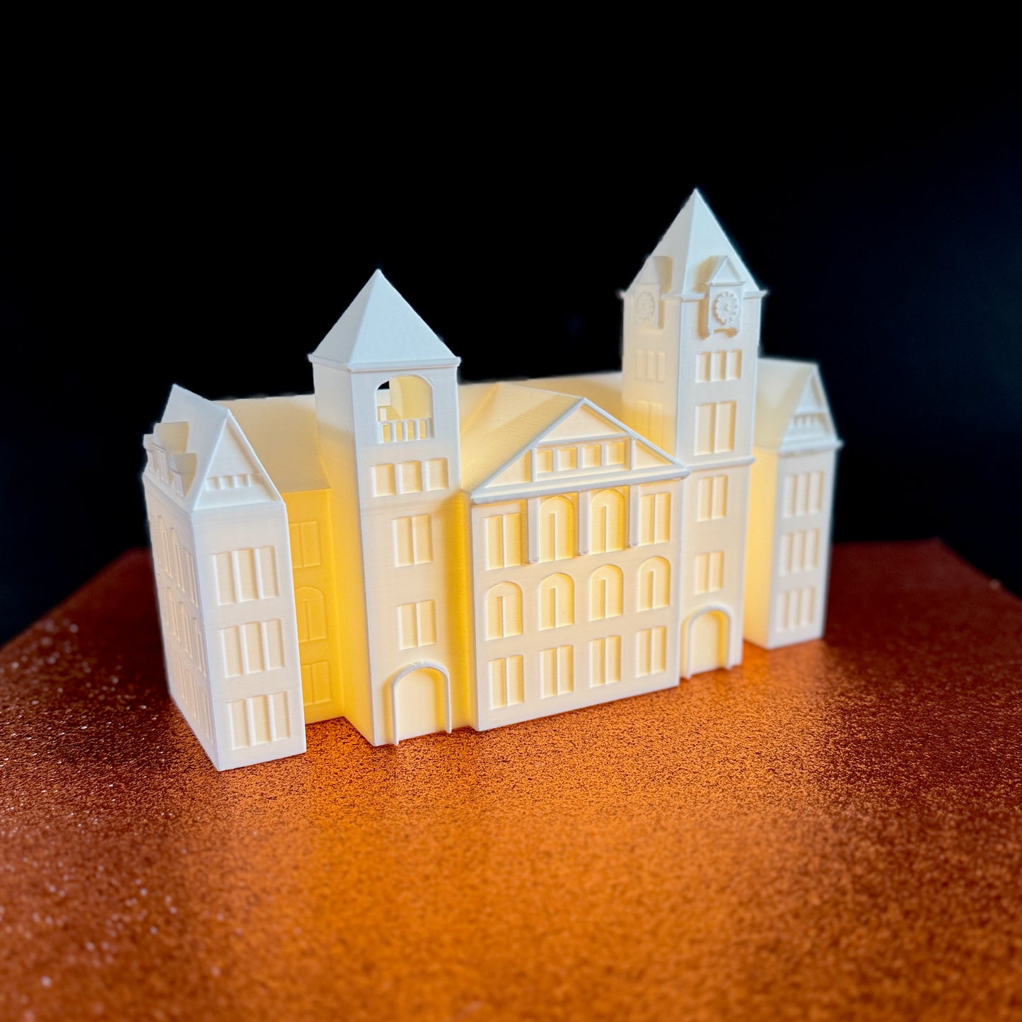 The Auburn Samford Hall figurine light, shown against an orange background.
