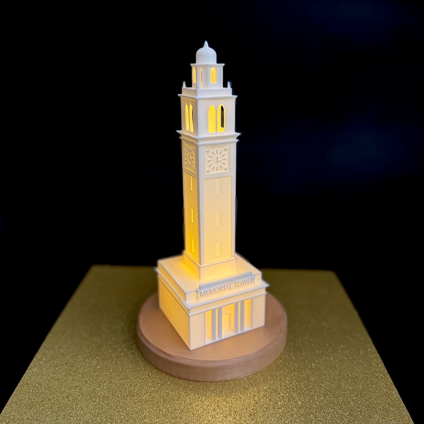 The LSU Memorial Tower figurine, shown against a gold background.
