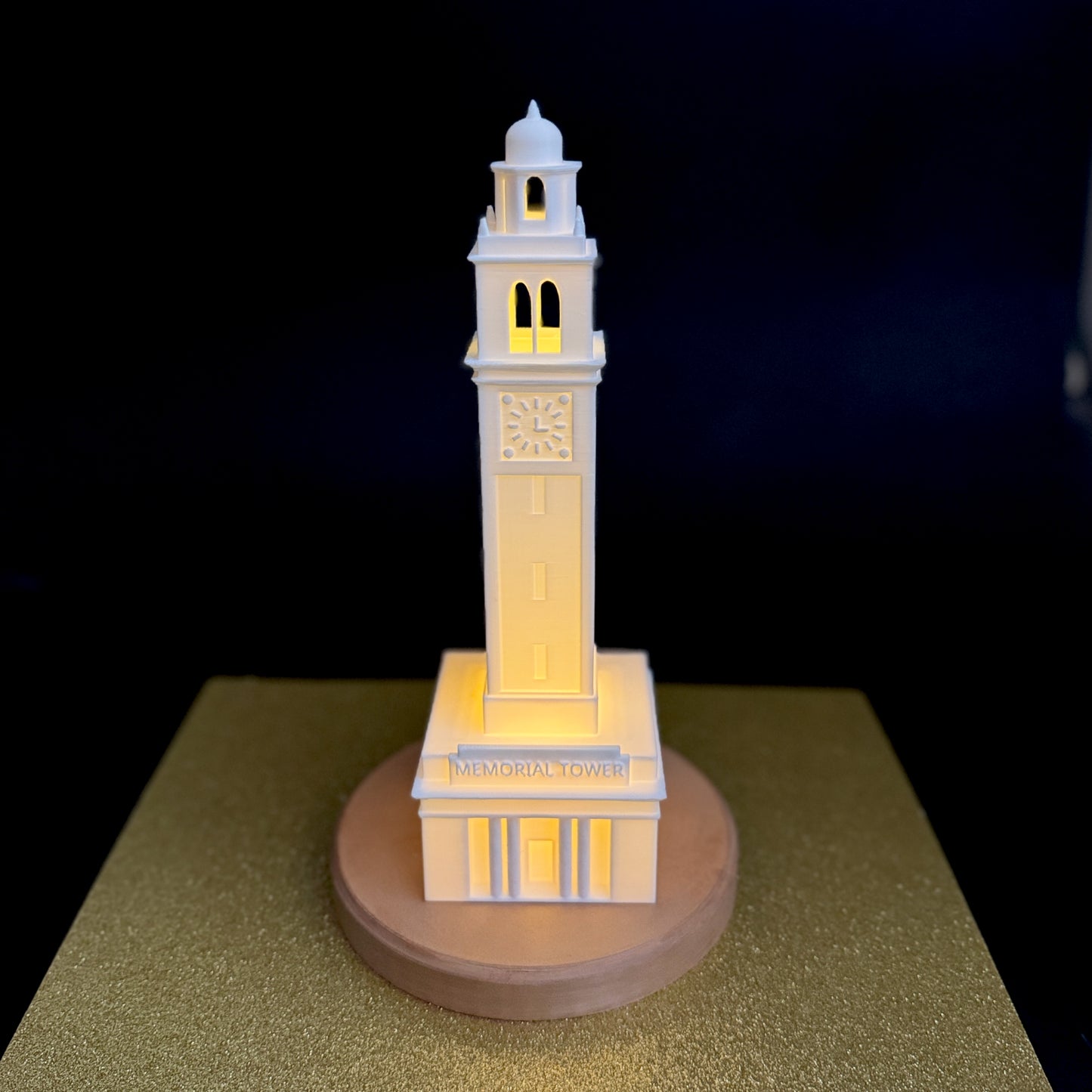 The LSU lamp, depicting the Memorial Tower campus building, and shown against a gold background.