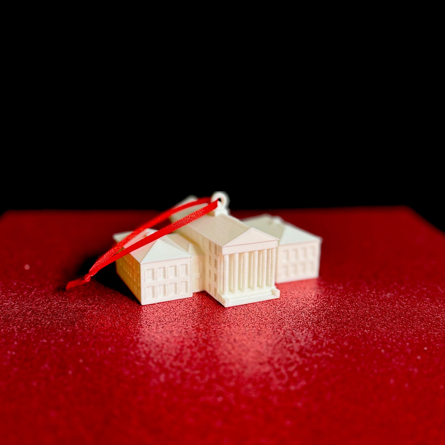 The Ole Miss keepsake ornament, shown against a red background.