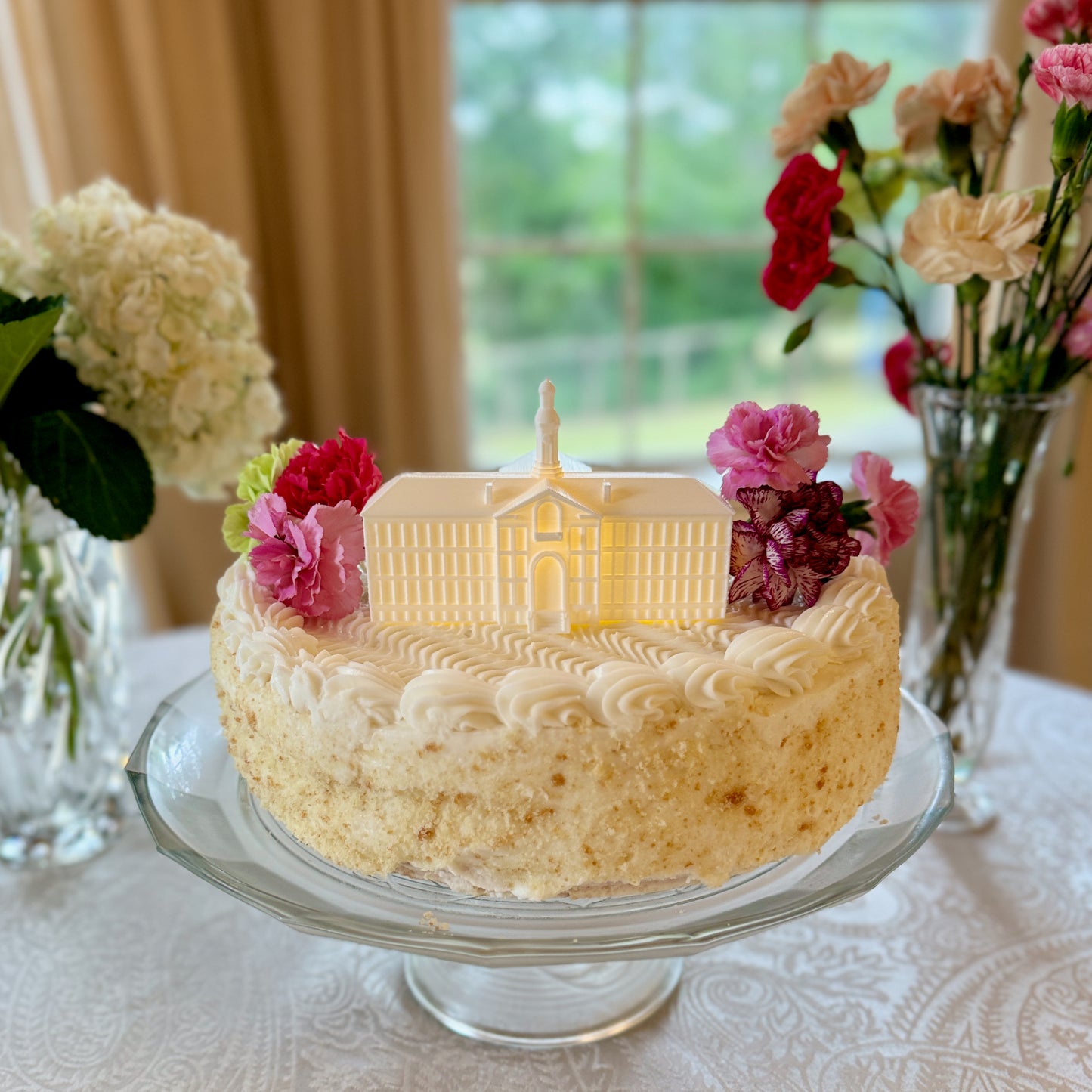 The Princeton cake topper designed as a replica of Nassau Hall with a light, shown on a graduation cake.