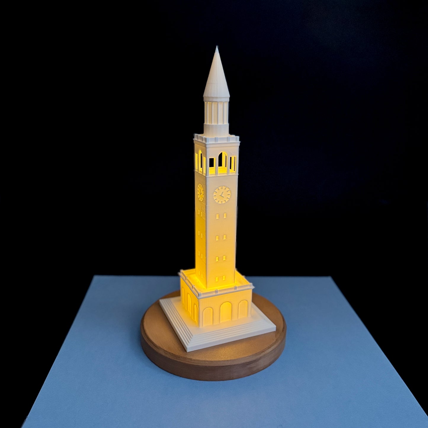 3D printed UNC Bell Tower LED light with wooden looking base, glowing warm white