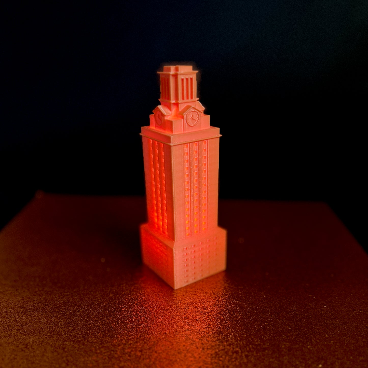 The UT Austin figurine of the UT Tower, shown in orange and used as a University of Texas gift or Texas Longhorns decor.