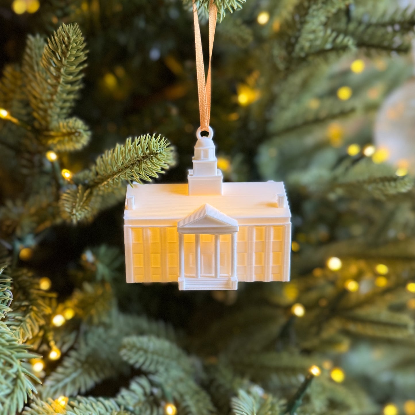 Front view of the lighted University of Iowa ornament, shown on a Christmas tree.