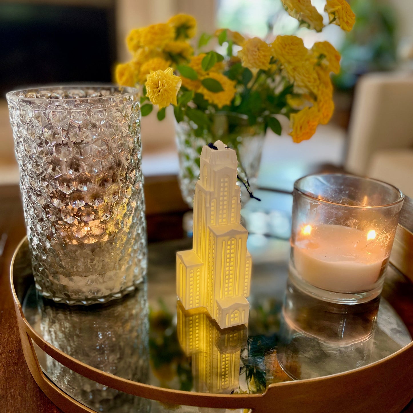 The University of Pittsburgh Christmas ornament, shown in a home and styled on a tray.