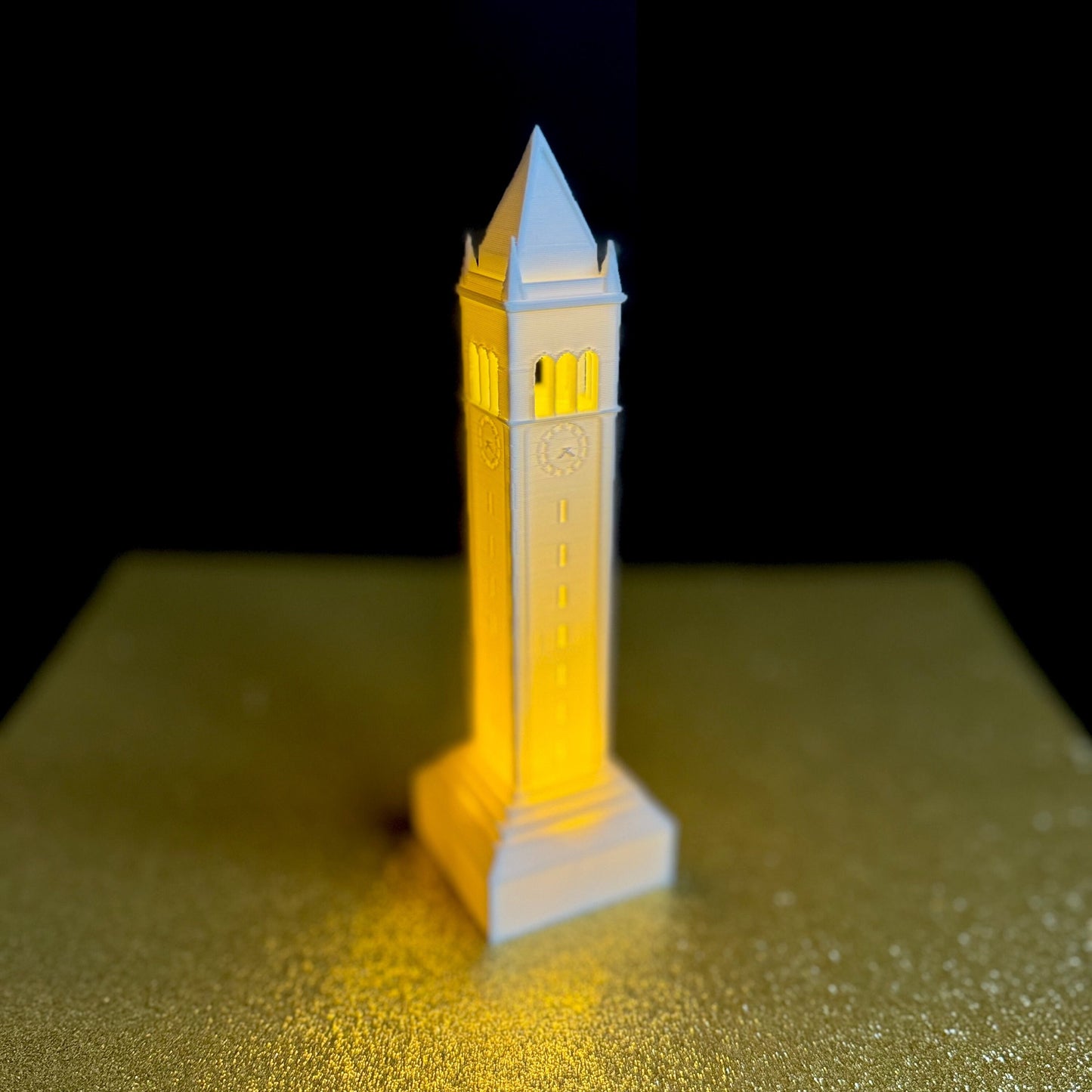 The Berkeley Campanile light, shown against a gold background, and used as dorm decor or a night light.