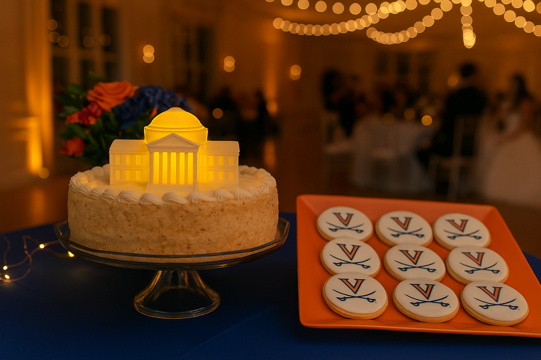Wedding groom’s cake featuring an illuminated 3D-printed University of Virginia Rotunda figurine as a topper, surrounded by UVA-themed cookies and soft twinkle lights in a romantic reception setting.