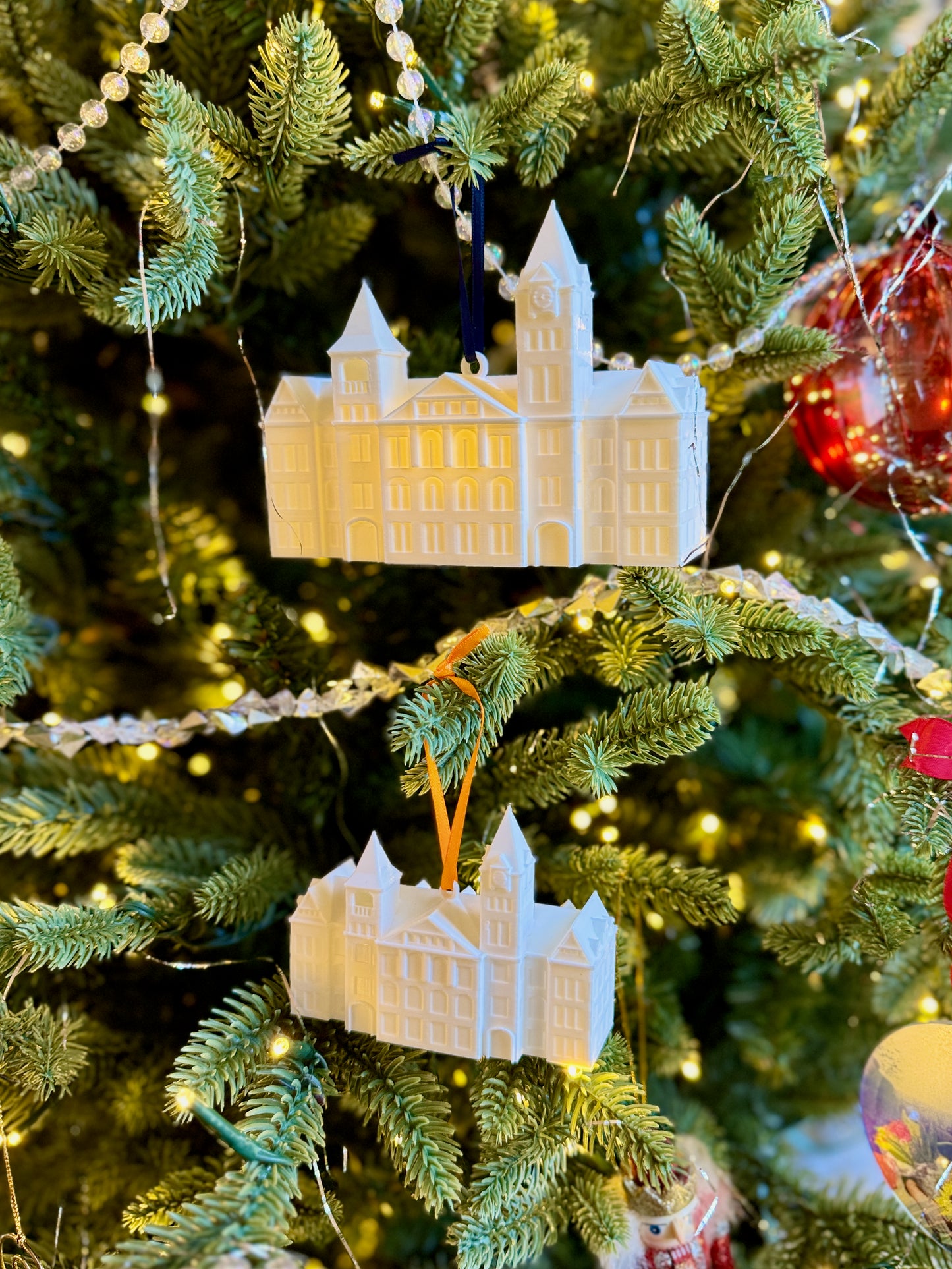 Two Auburn alumni ornaments for the Samford Hall building, shown on a Christmas tree.