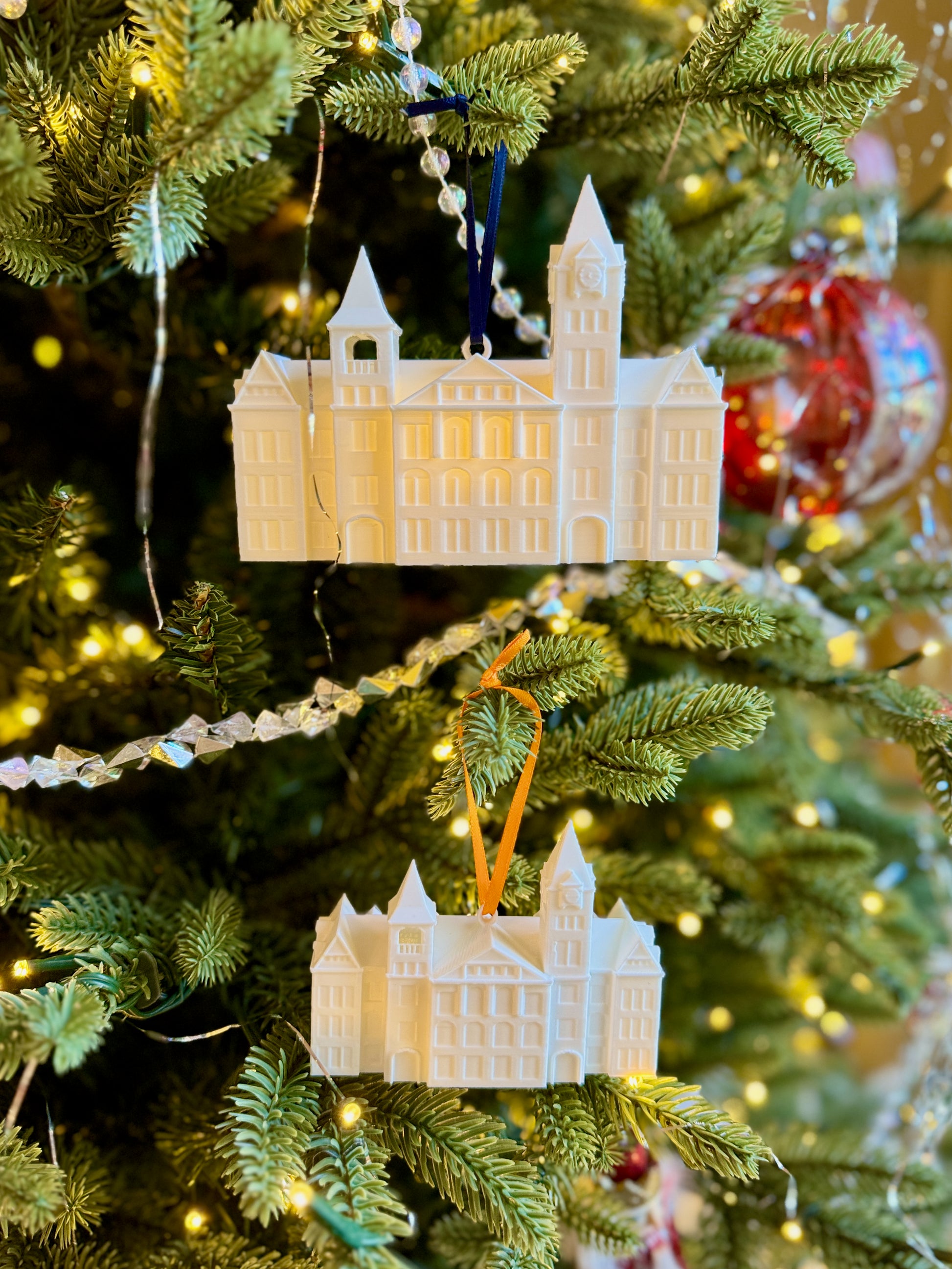 Holiday ornaments for Auburn students, designed as the Samford Hall building and shown on an Auburn tree.