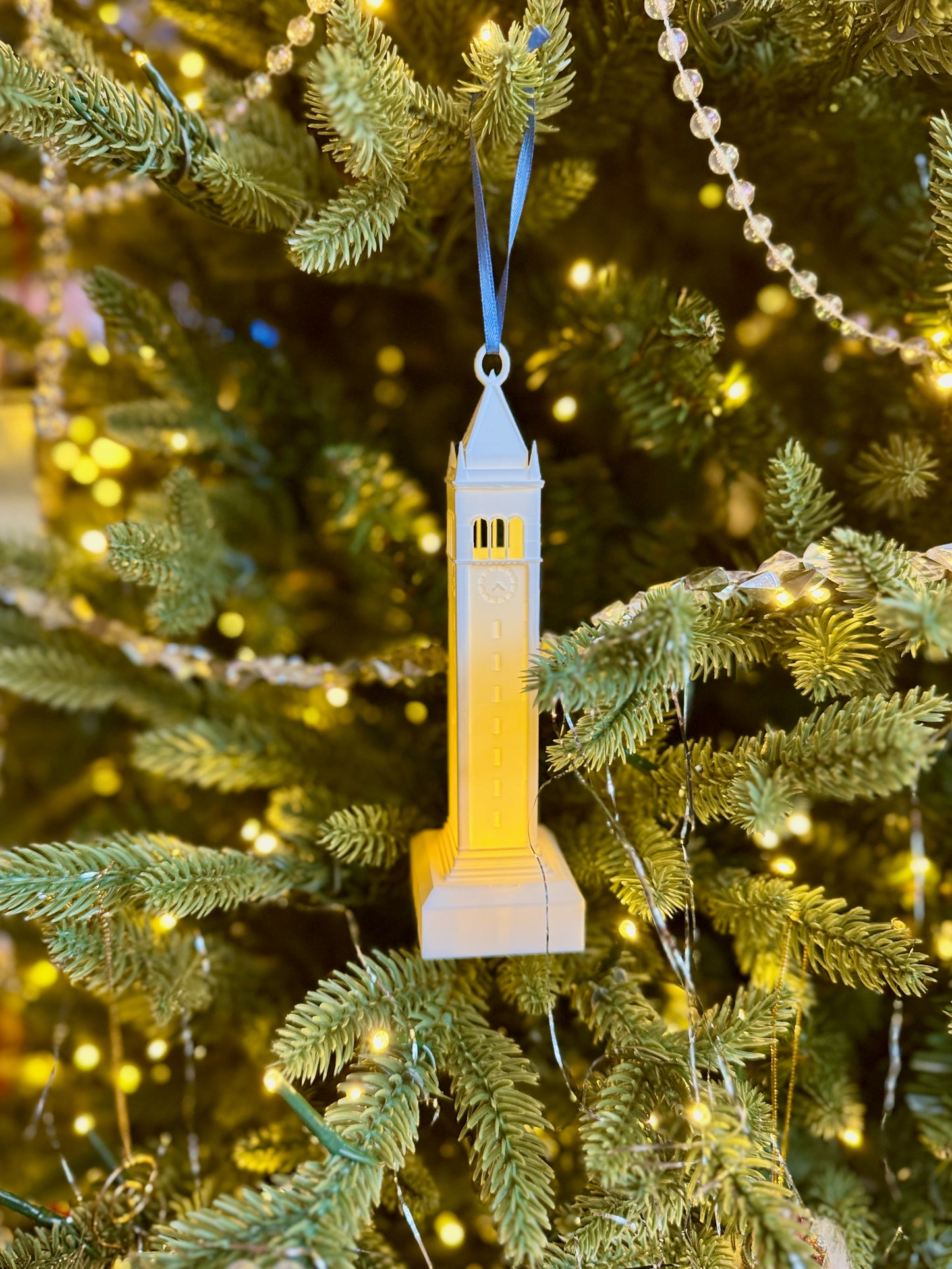 The Sather tower ornament with LED light, shown on a Christmas tree.