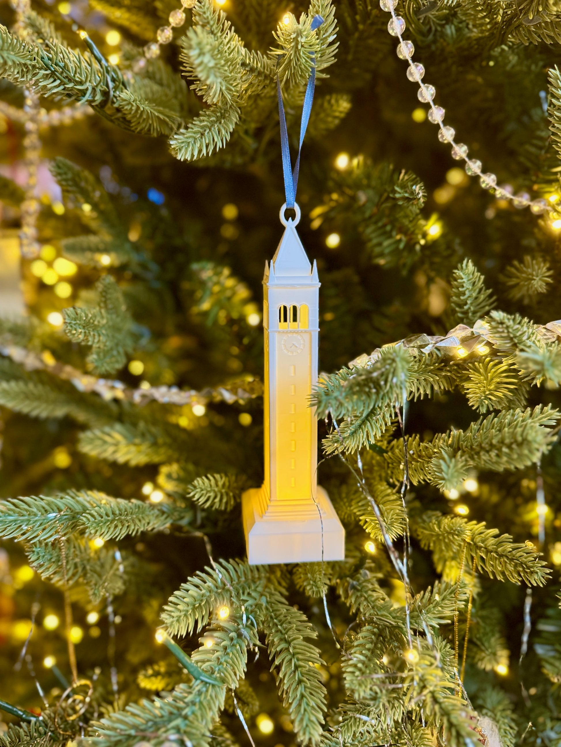 The Sather tower ornament with LED light, shown on a Christmas tree.