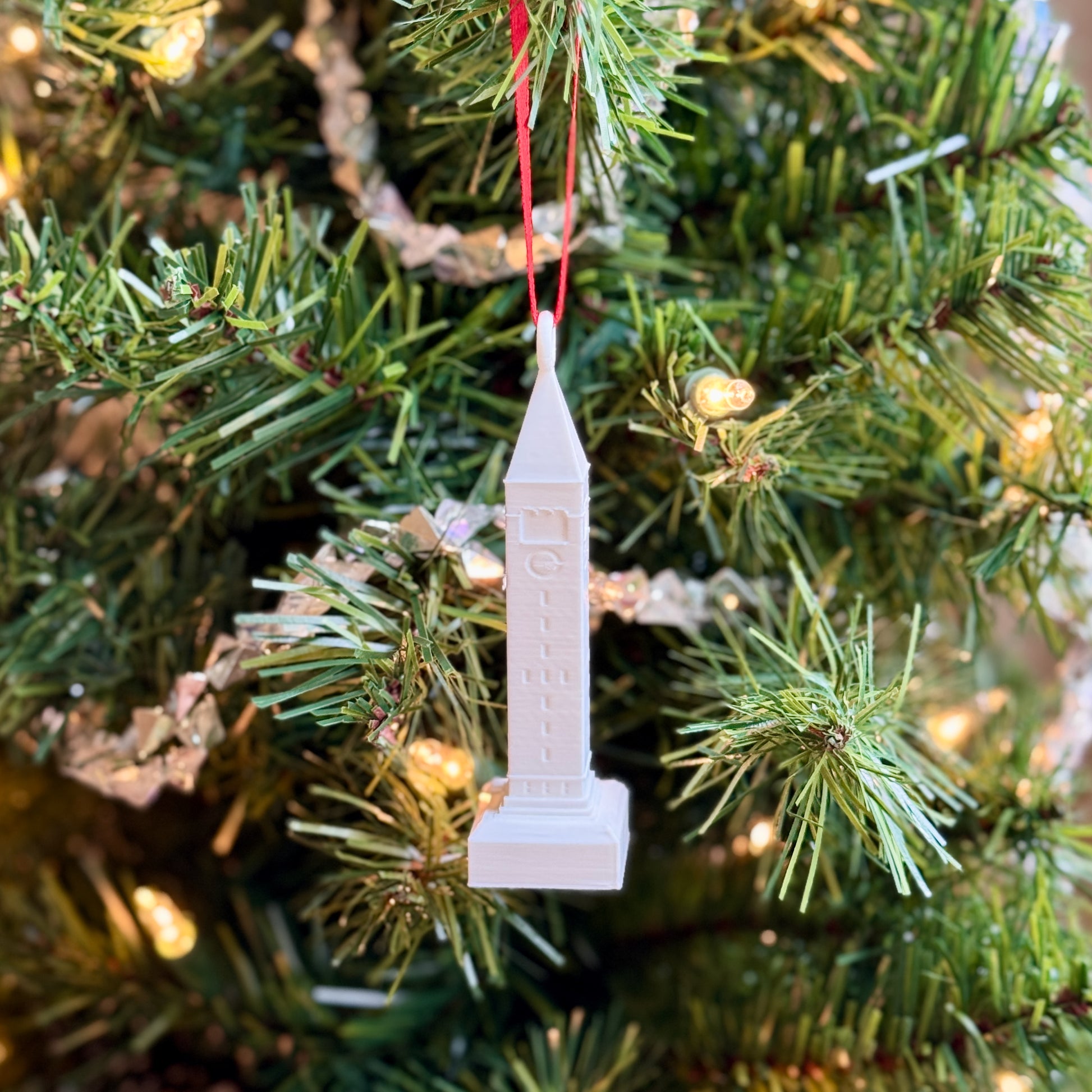 The Cornell Ornament featuring the McGraw Tower, shown on a Christmas tree.