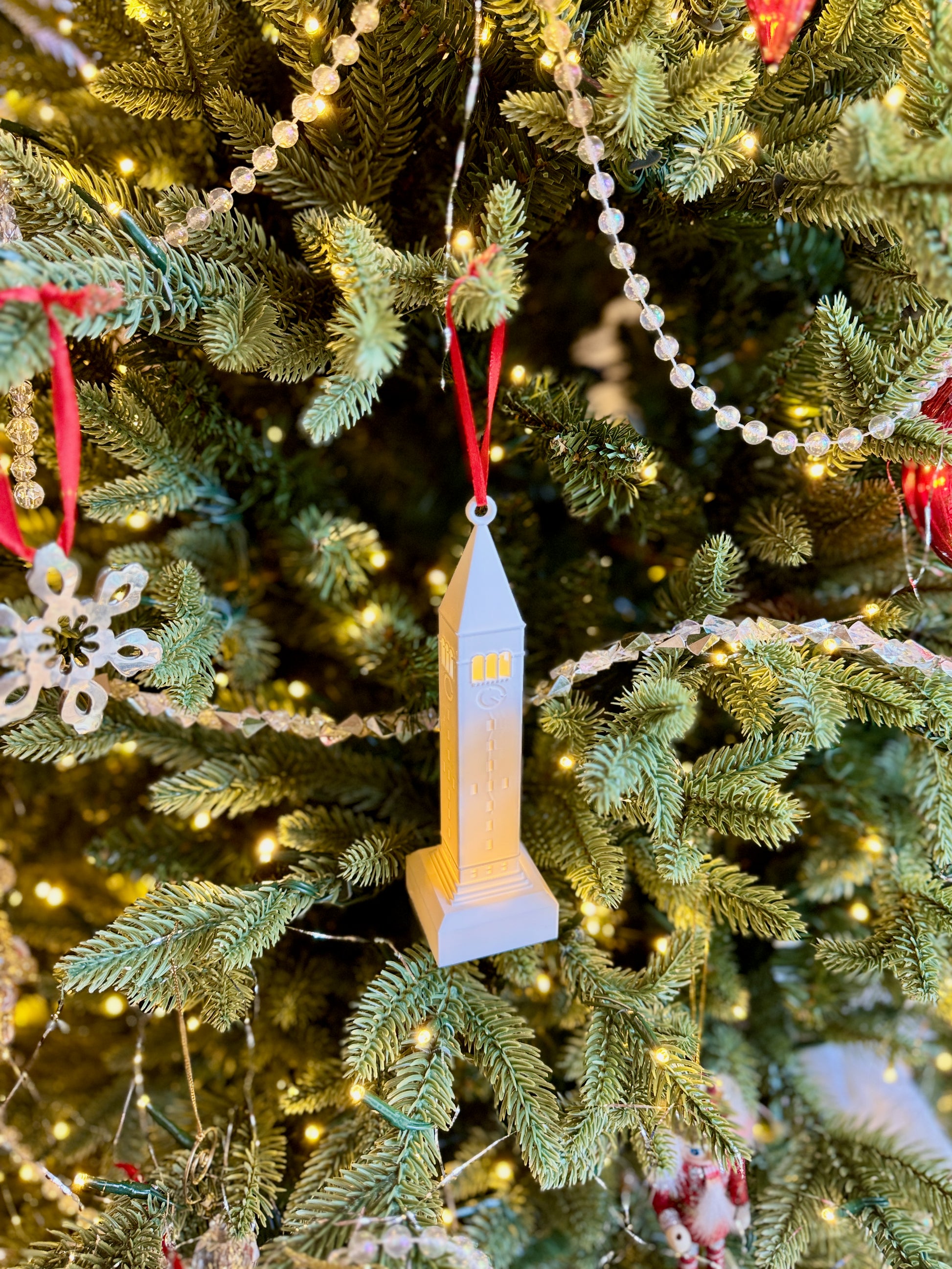 The Cornell student ornament designed as the McGraw Tower and shown with an LED light.