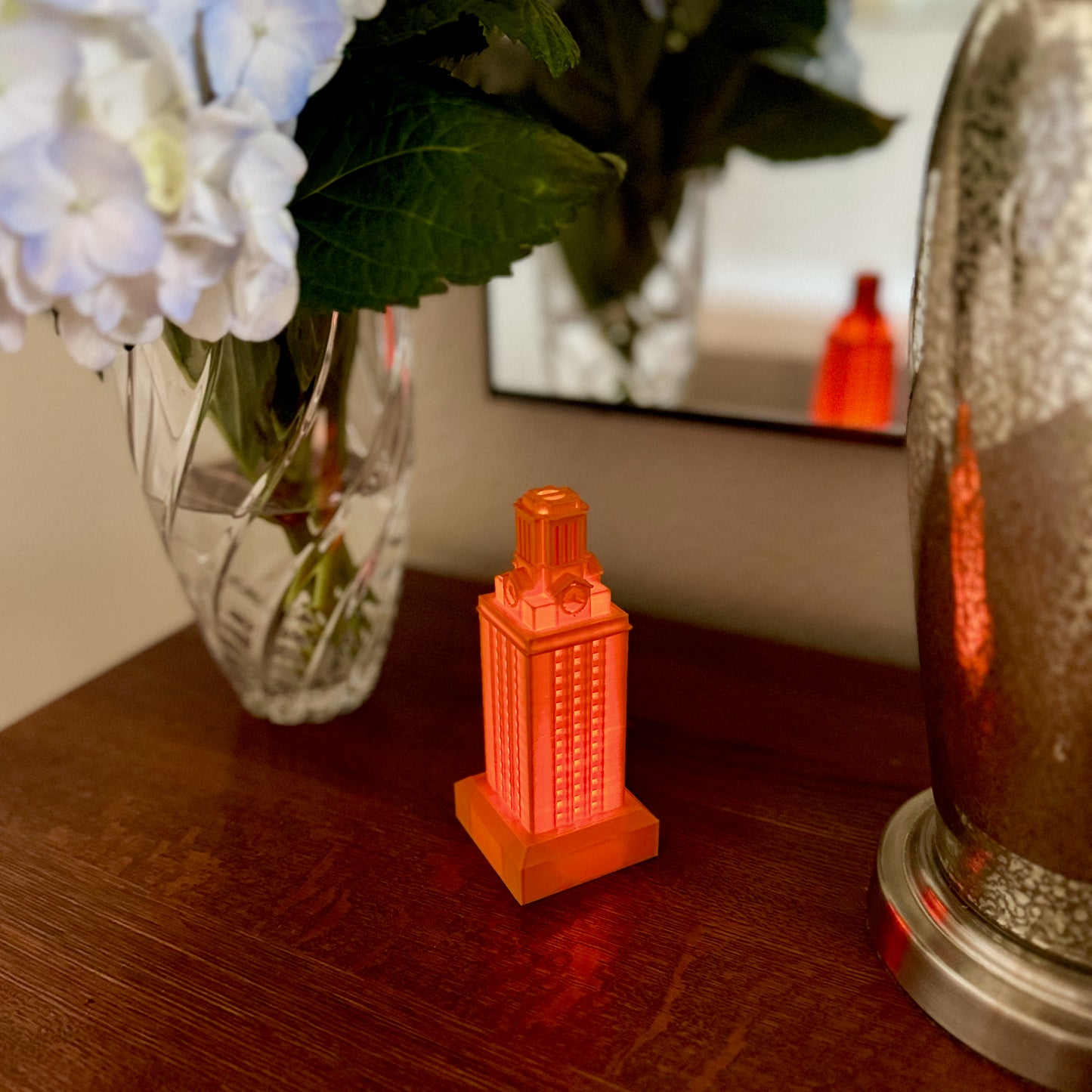 The University of Texas campus figurine, a UT Tower light in burnt orange, shown on a side table.