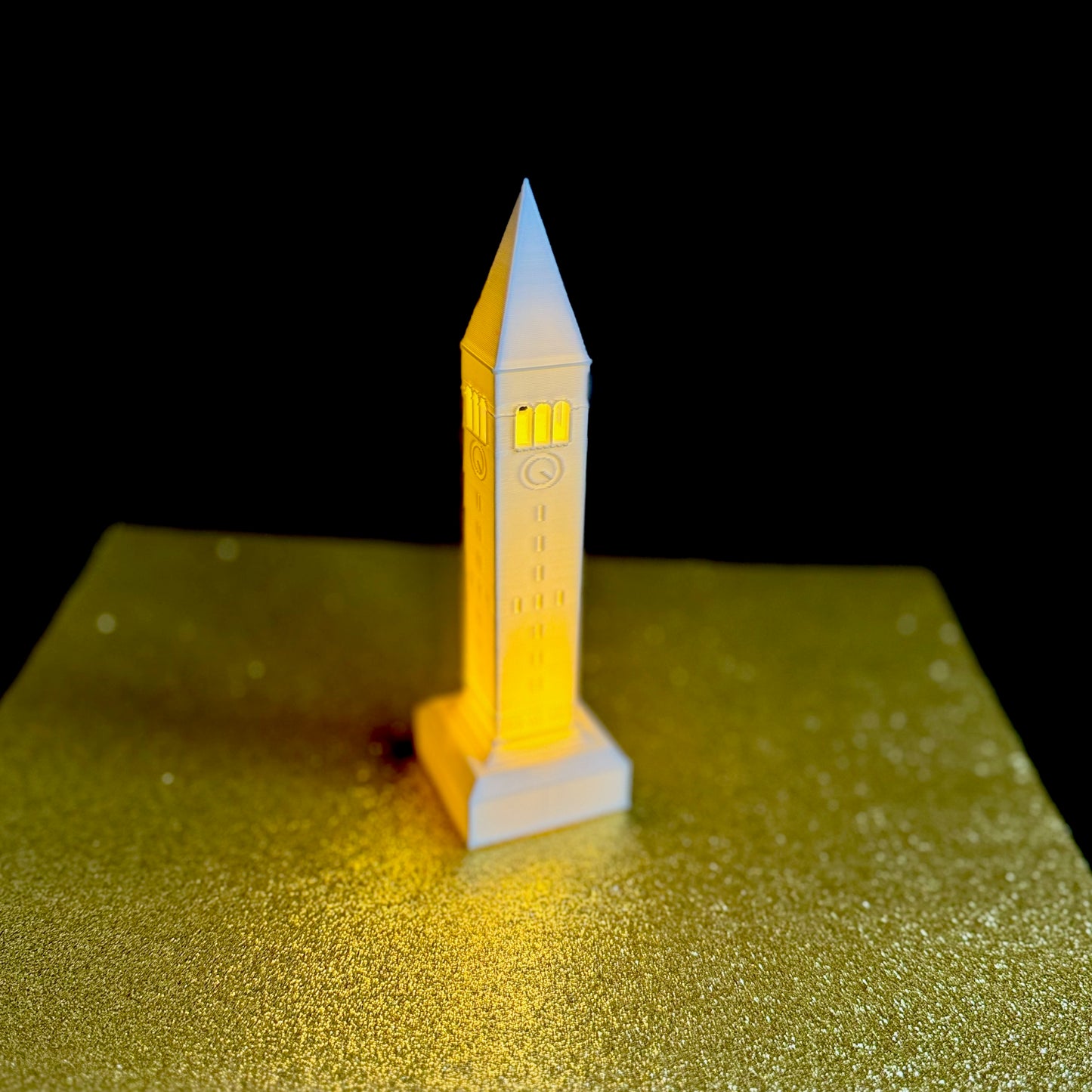 The Cornell University light, shown against a gold background.