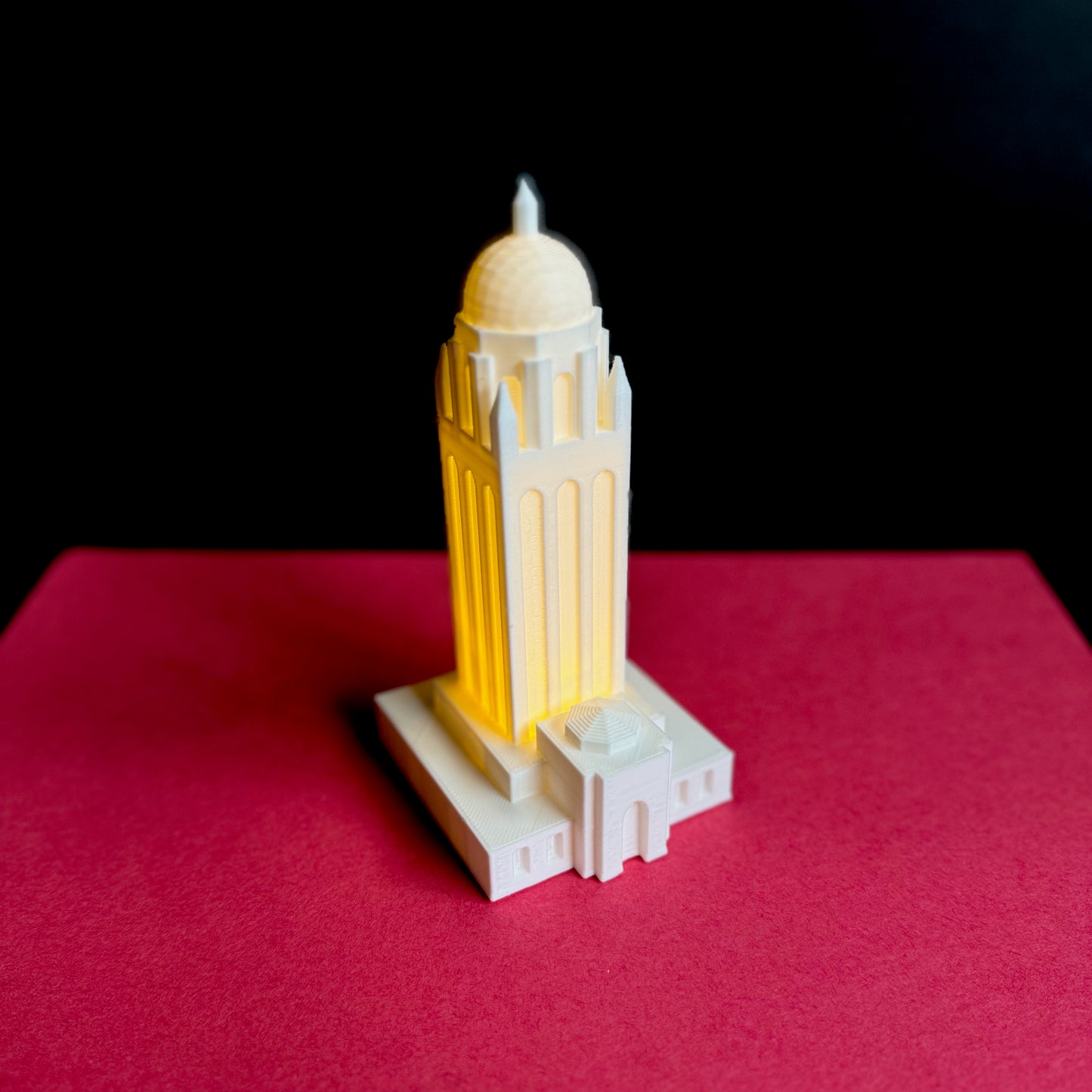 The Stanford Hoover tower lighted figurine, shown against a cardinal red background.