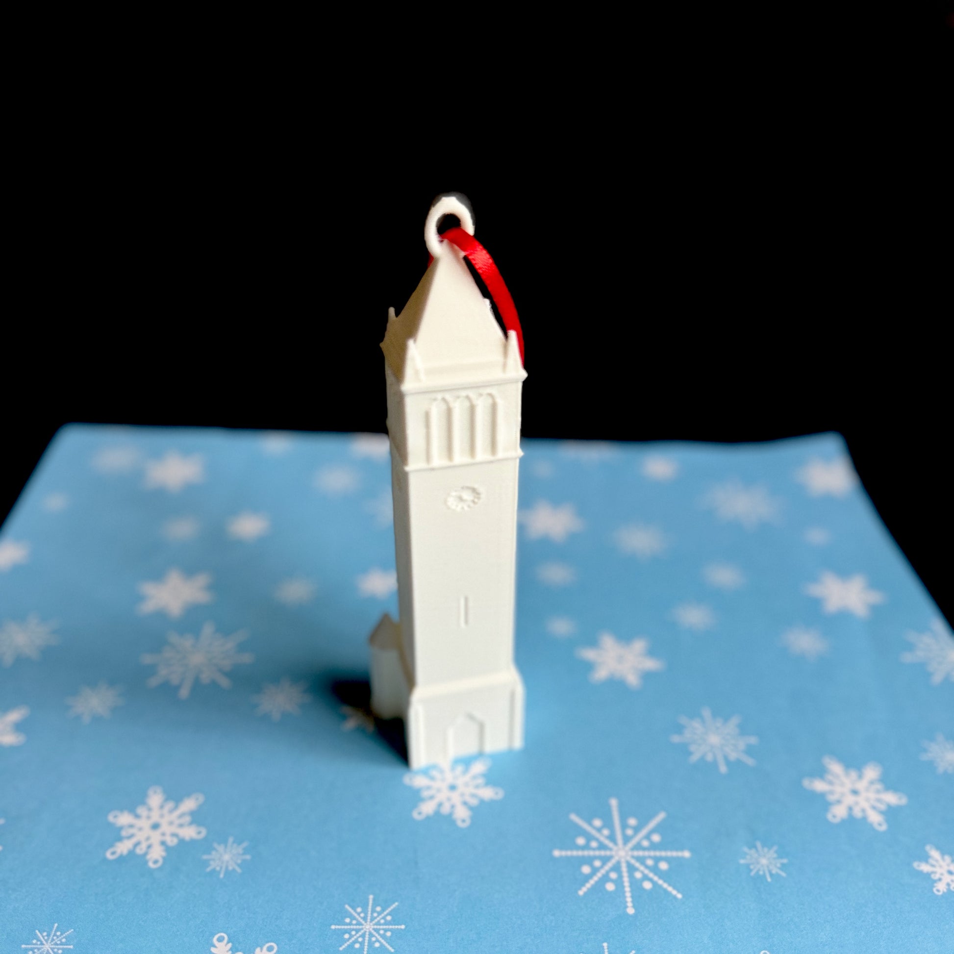 The Iowa State University ornament, shown against a blue holiday background.