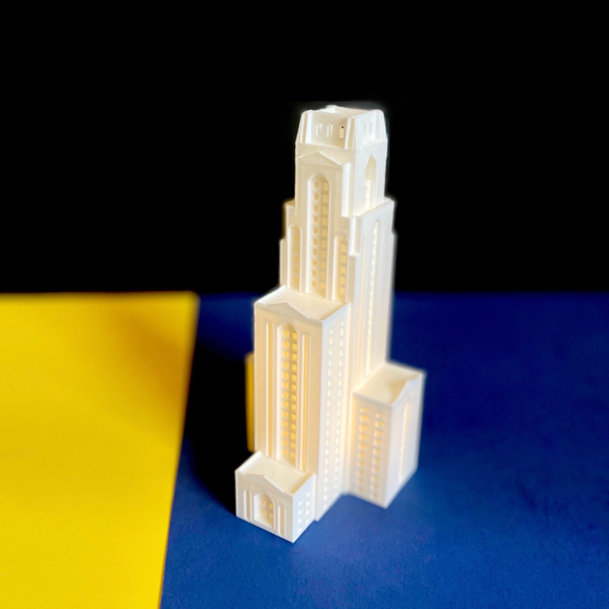 The University of Pittsburgh gift for him, the Pitt Cathy figurine displayed in a background of Pitt colors.