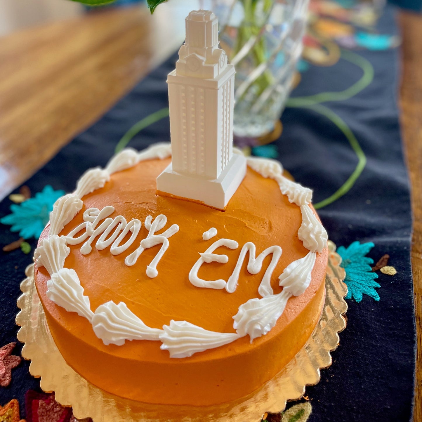 The UT Austin cake topper shown on a burnt orange University of Texas Longhorns graduation cake.