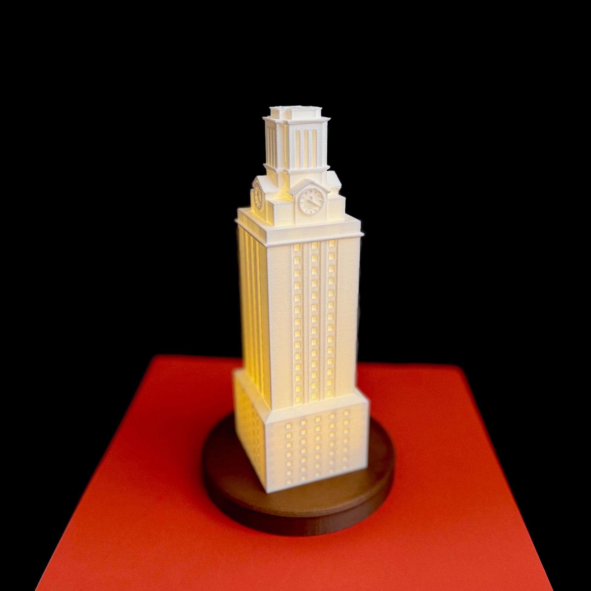 The UT Tower lamp, shown against an orange background.