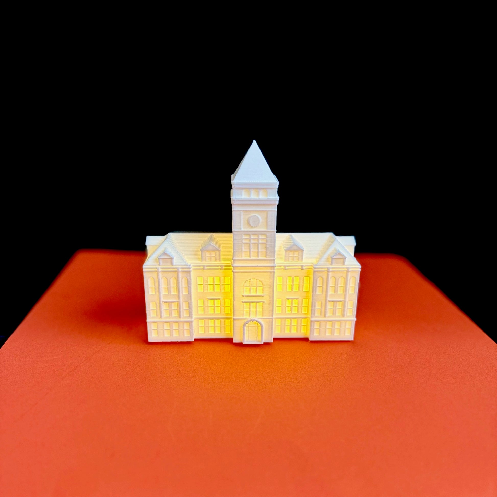 The Clemson University Tillman Hall light, shown against an orange background.