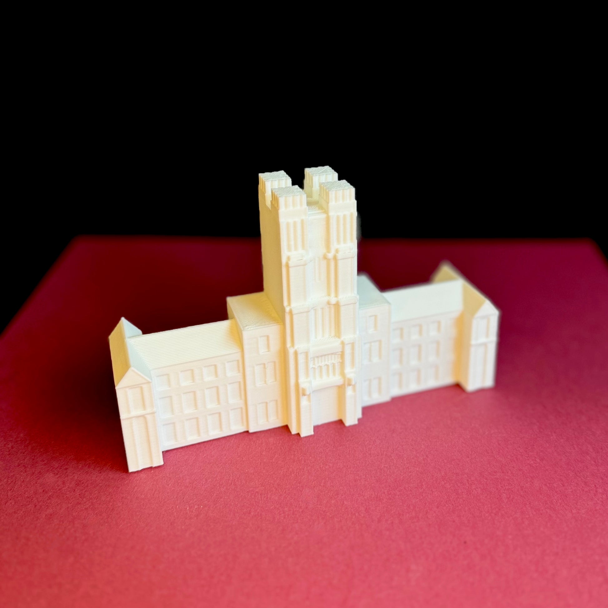 The Virginia Tech figurine of Burruss Hall, shown on a maroon background.