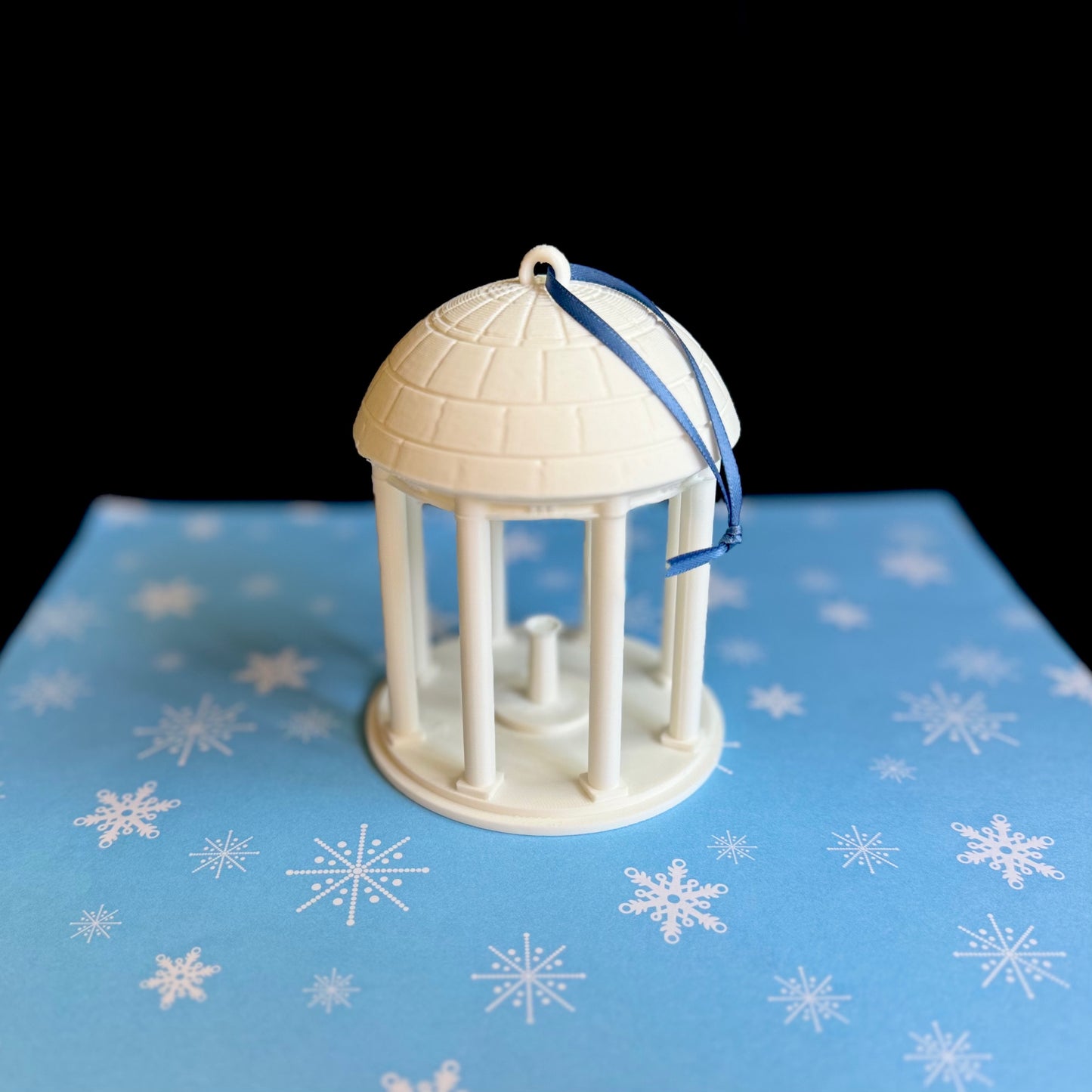 The larger Old Well ornament, shown against a blue holiday background.