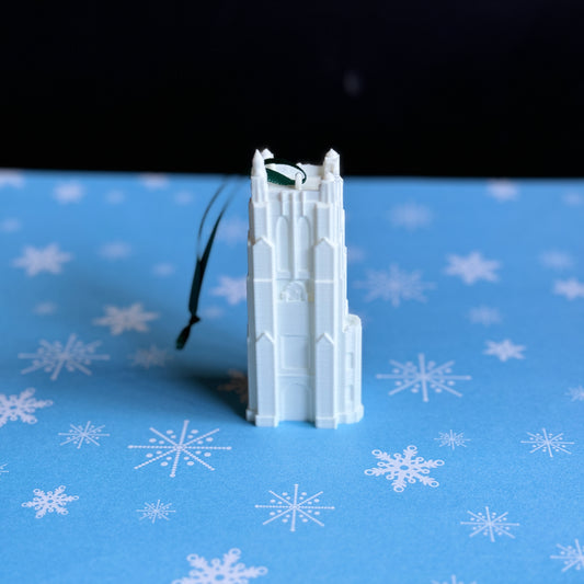 The 3D printed Michigan State University ornament, shown against a blue holiday background.