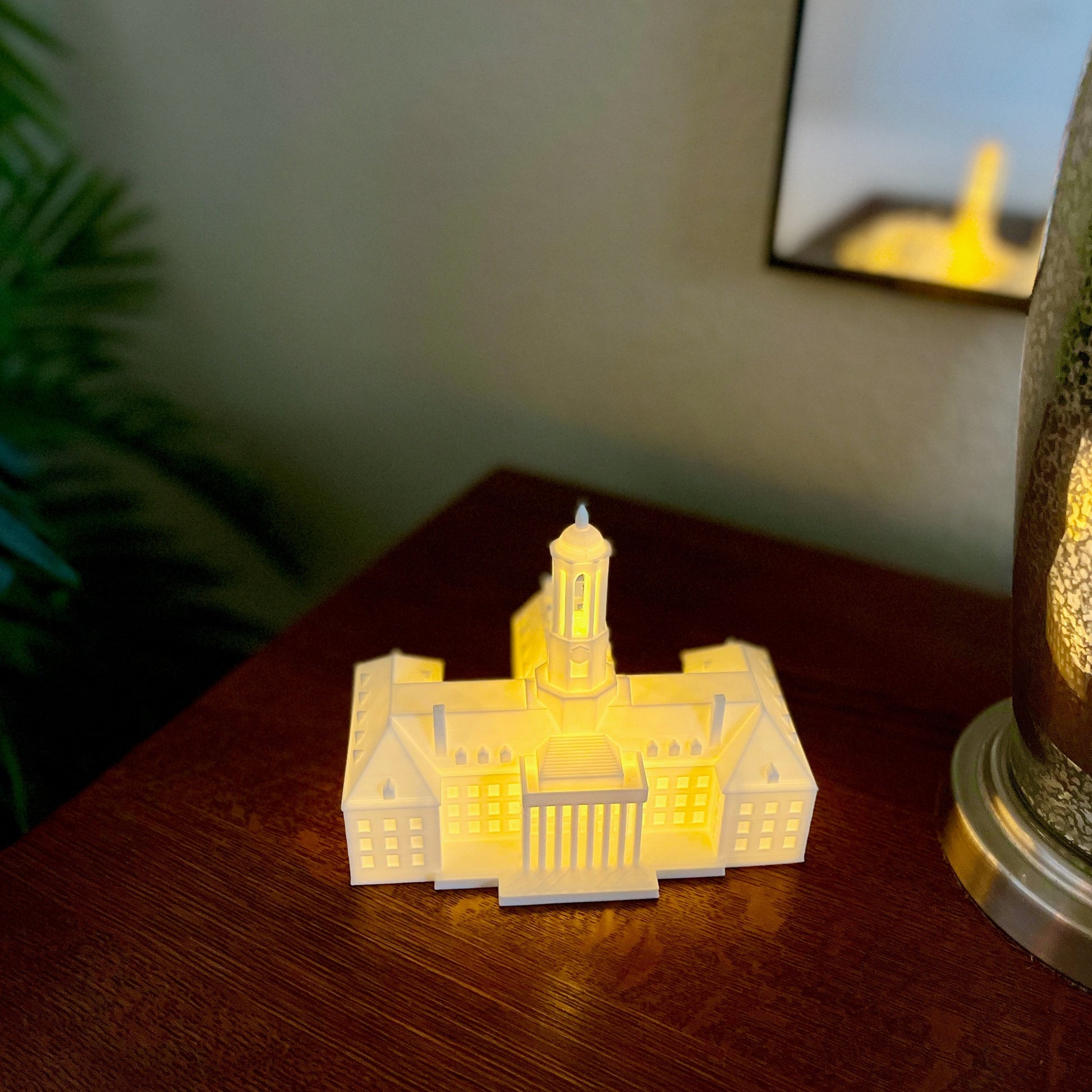 The Penn State Old Main keepsake, shown on a dorm room side table.