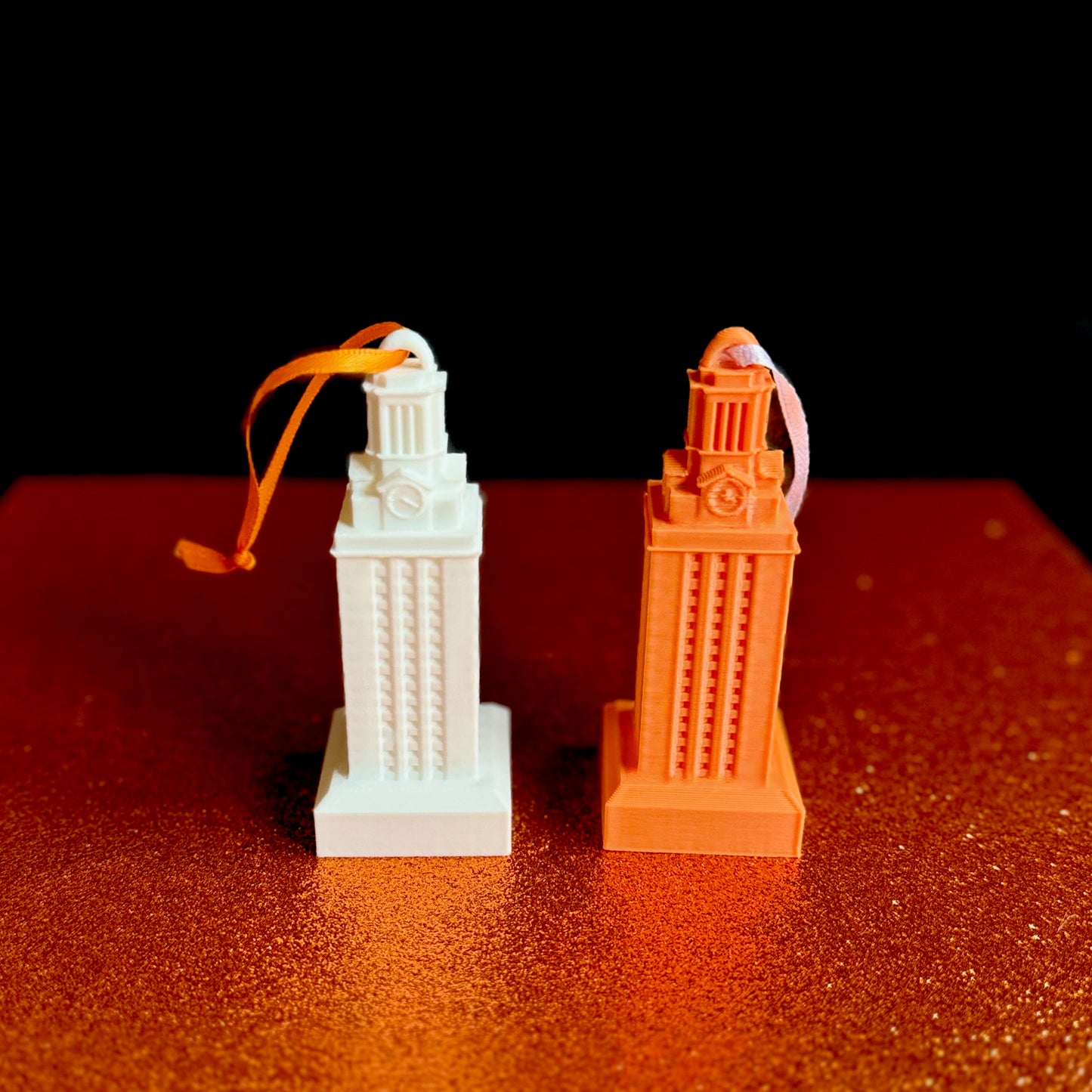 The UT Austin ornaments, shown side by side against a burnt orange background.