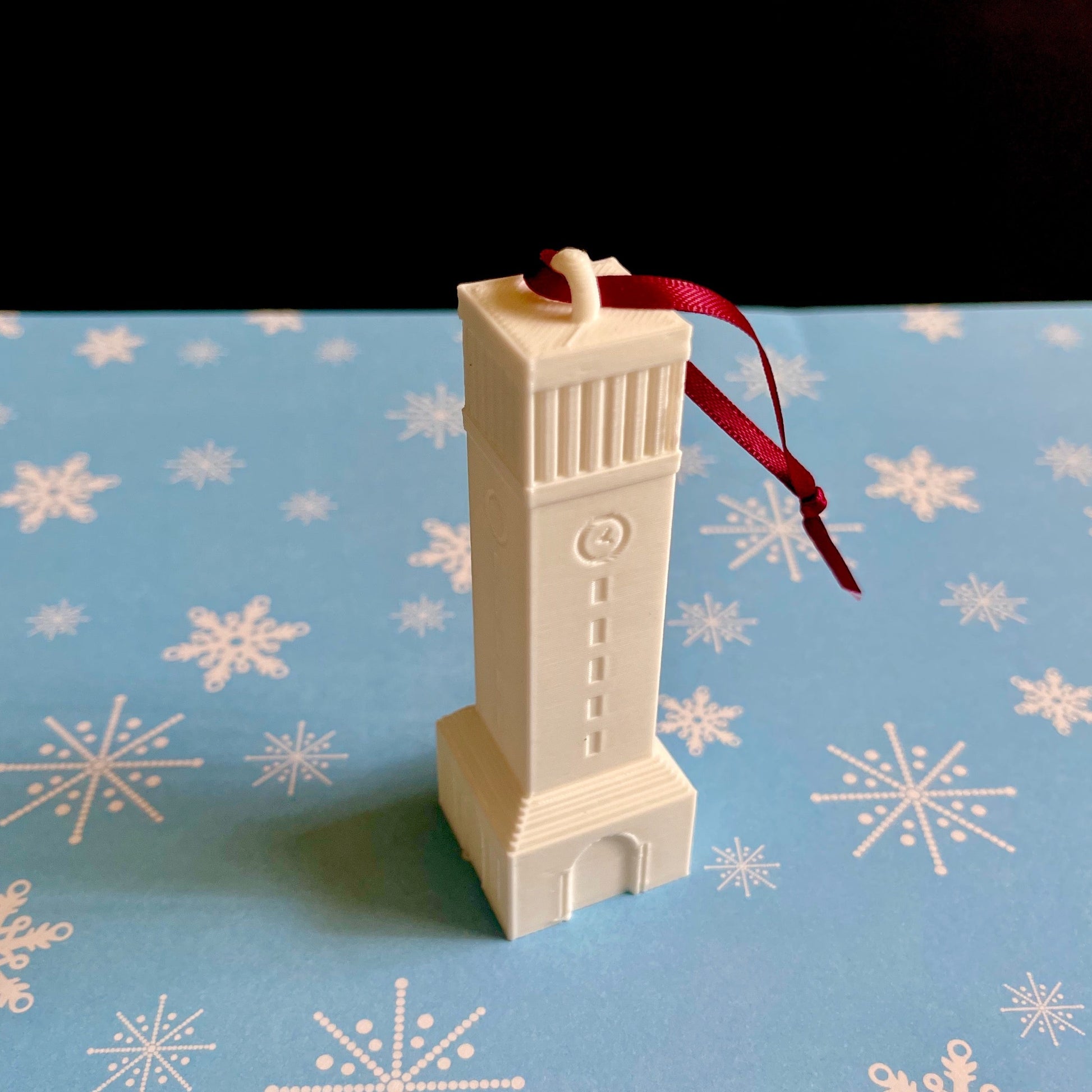 The Aggie Christmas ornament, shown against a blue holiday background.