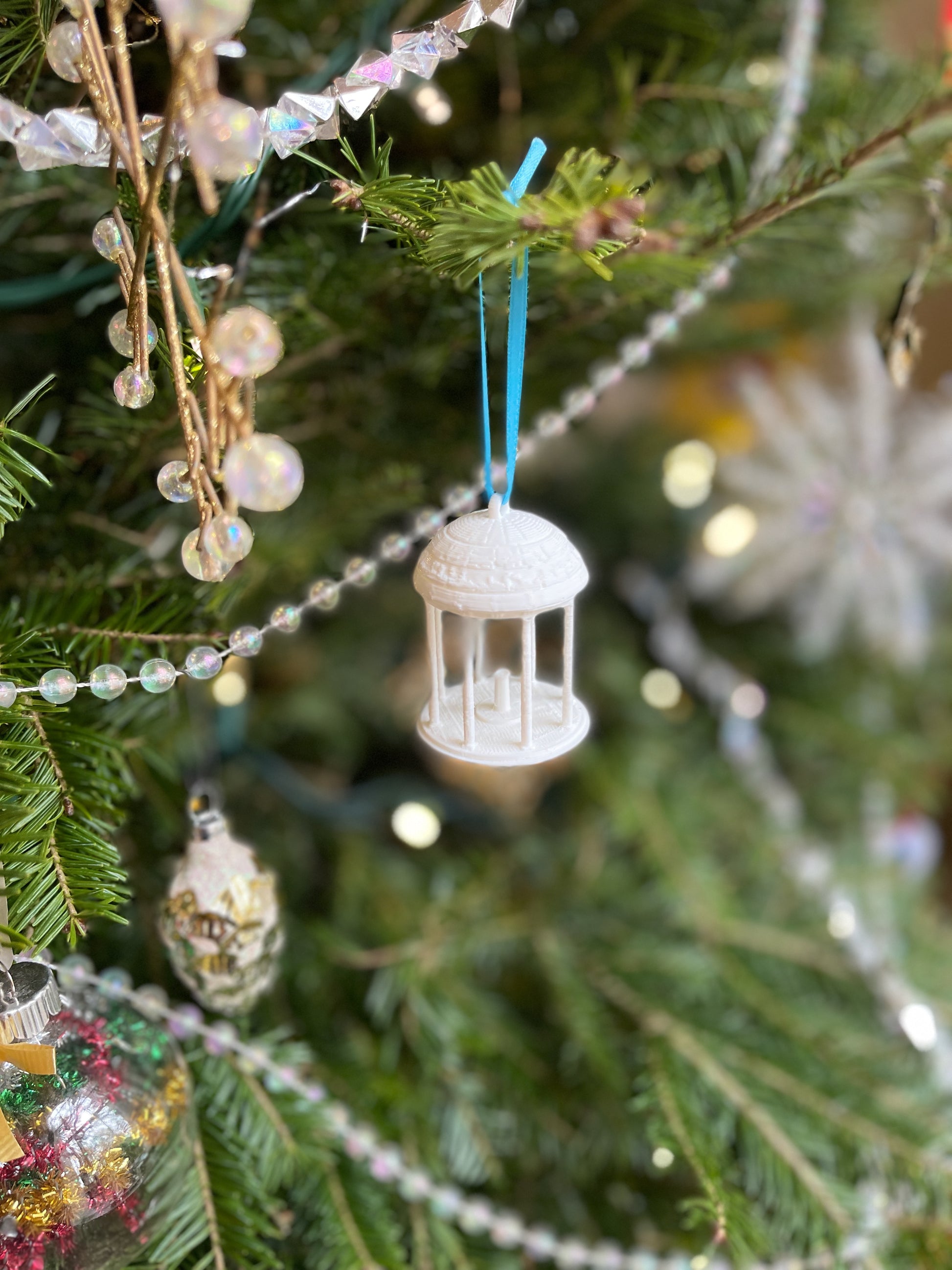 The small UNC Old well ornament, shown on a Christmas tree.