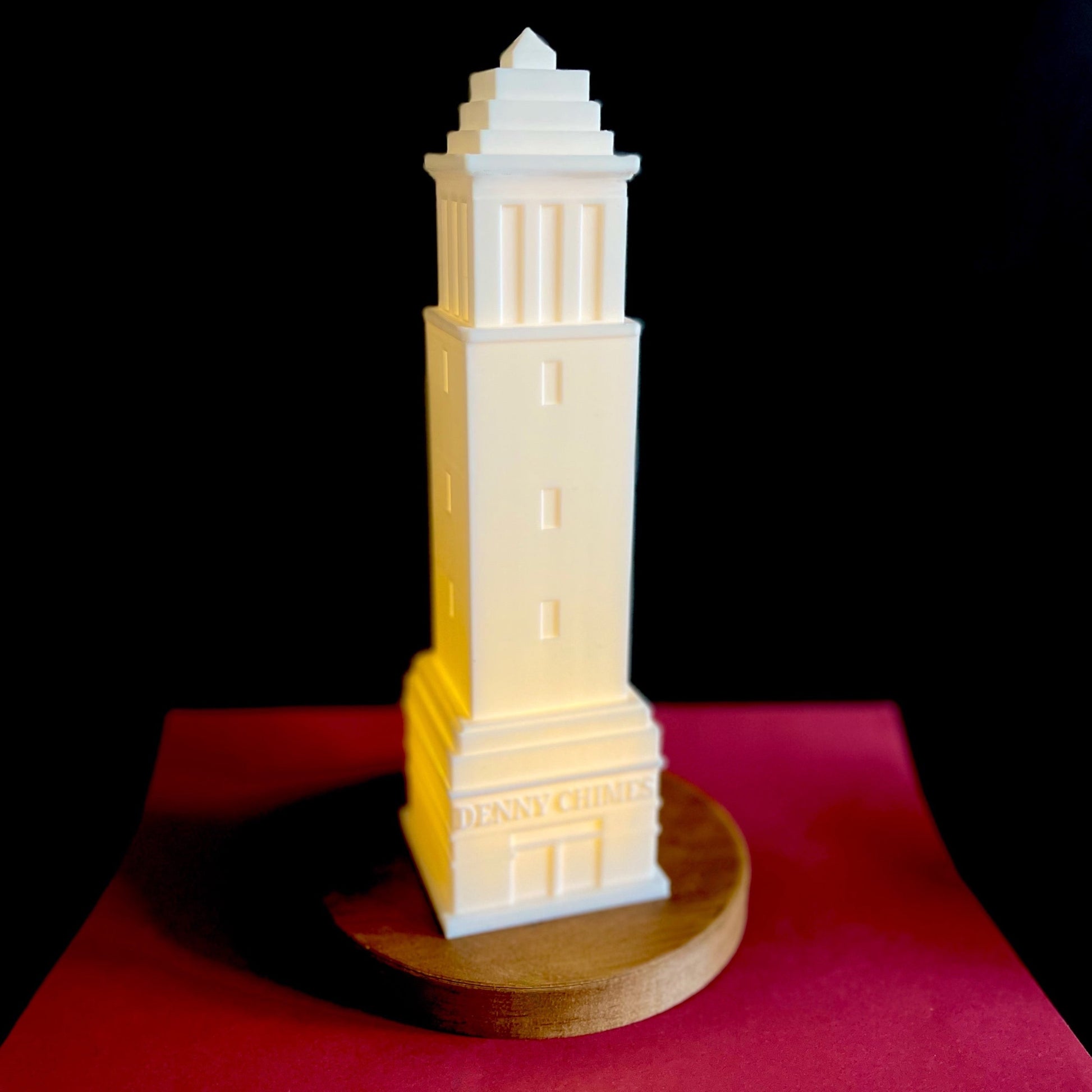 The University of Alabama Denny Chimes light, shown against a crimson background.