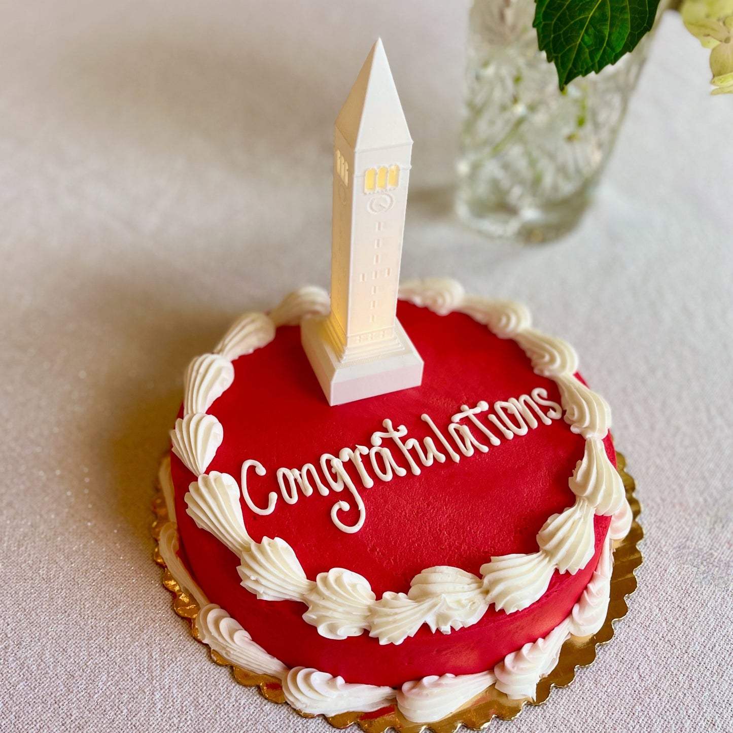 The lighted Cornell cake topper, shown on a red Cornell graduation cake.