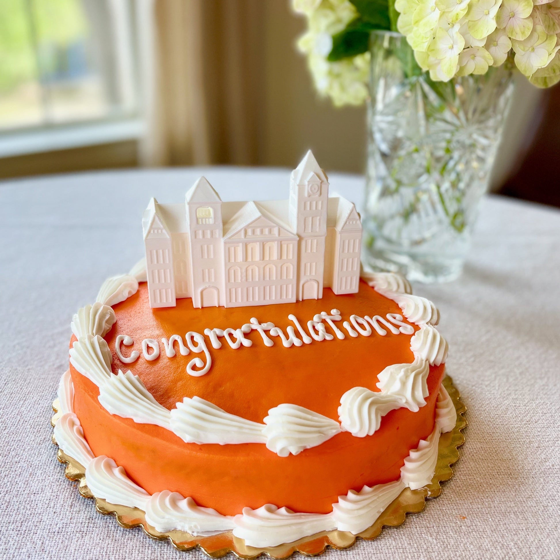 The Auburn University cake topper, shown on an orange Auburn graduation cake.