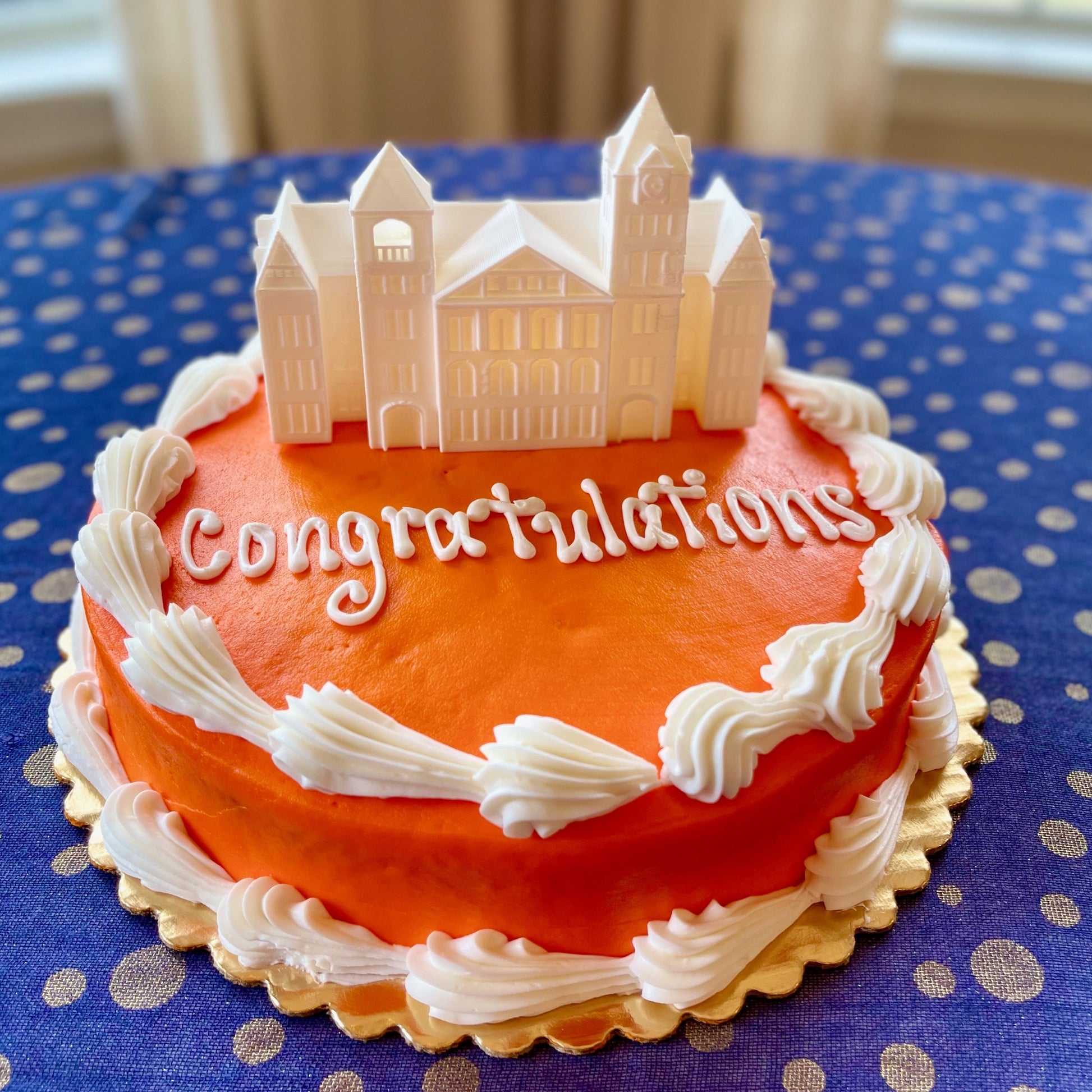 The lighted Auburn cake topper, shown on an orange and blue Auburn graduation cake. 