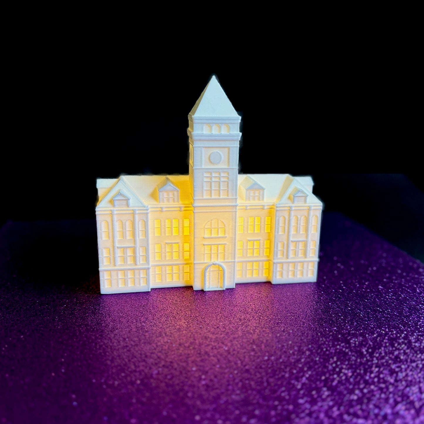 The lighted Clemson figurine of Tillman Hall, shown against a purple background.