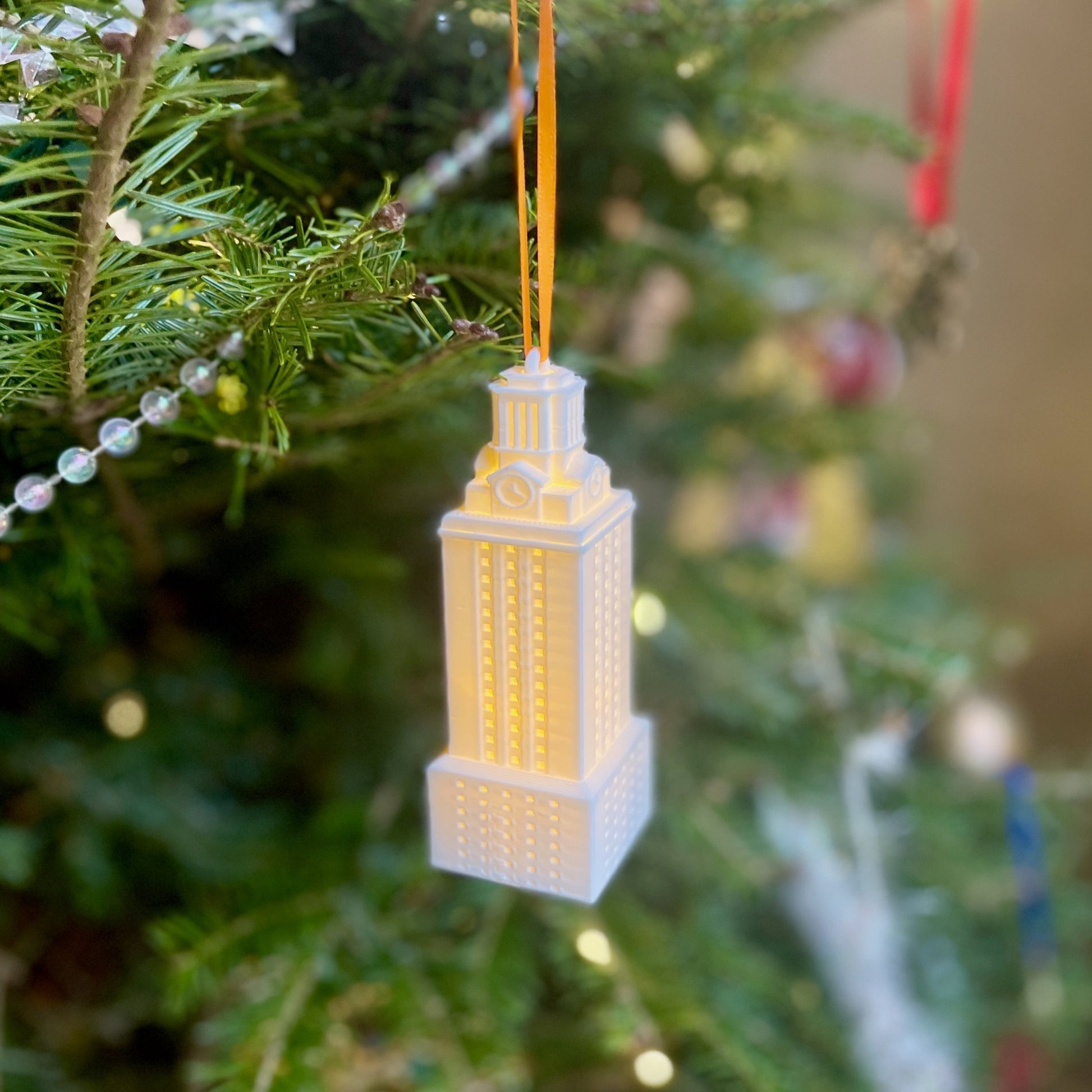 The lighted University of Texas ornament, shown on a Christmas tree.