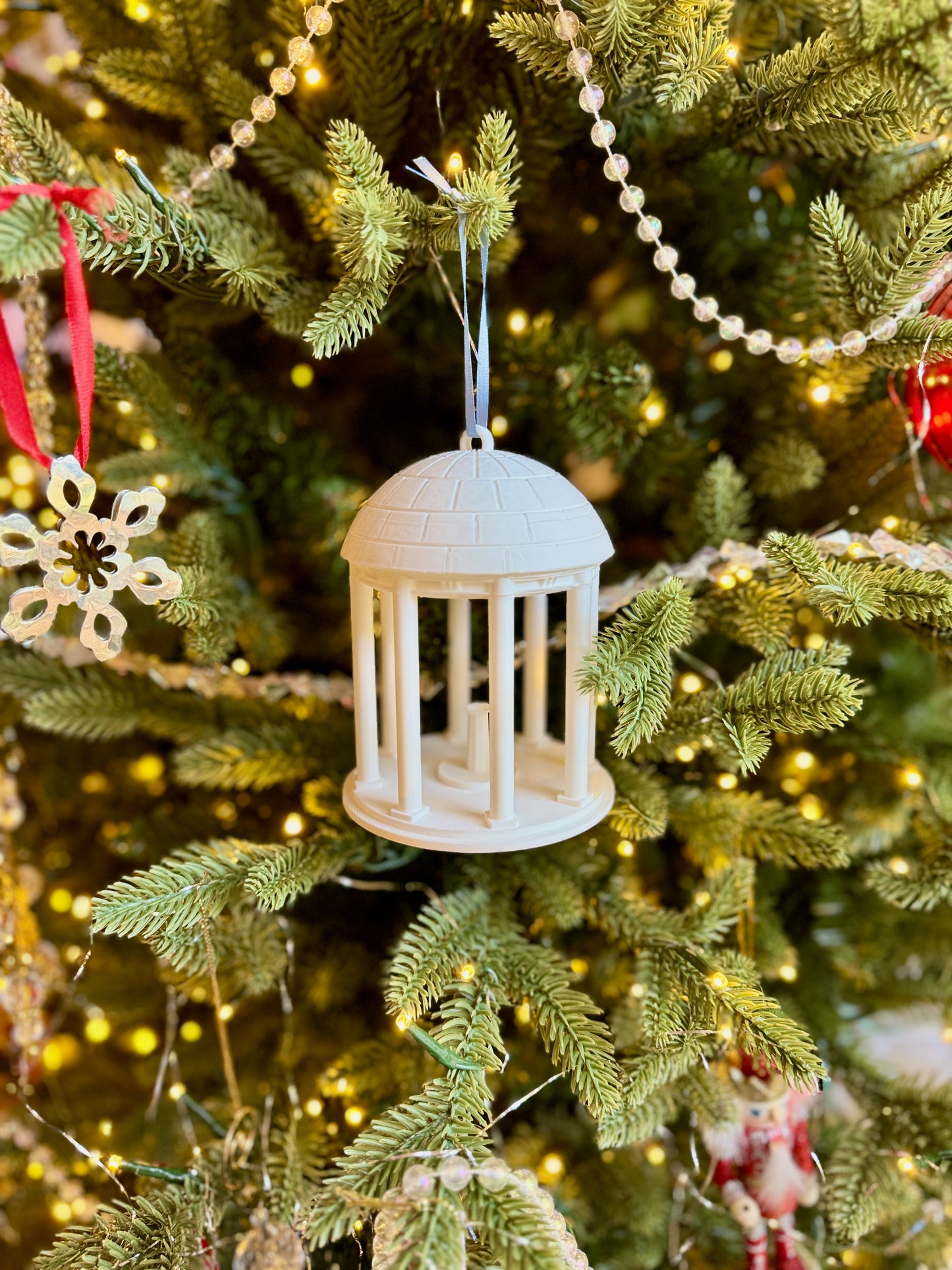 The Old Well ornament for UNC alumni, shown on a Christmas tree.
