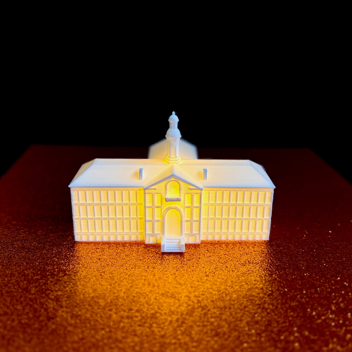 The Princeton Nassau Hall lighted figurine, shown against an orange background.