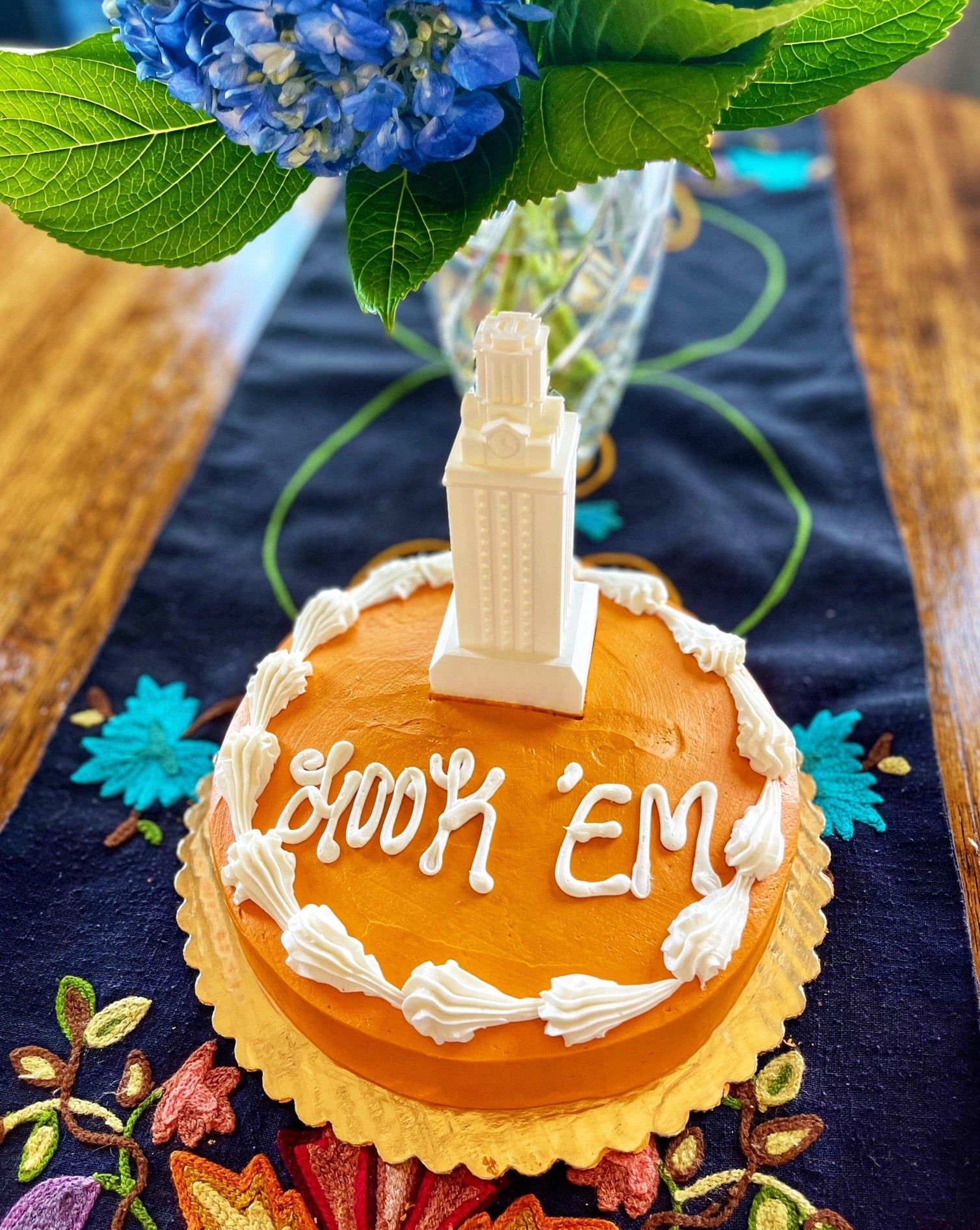 The University of Texas cake topper, shown on a burnt orange University of Texas graduation cake.