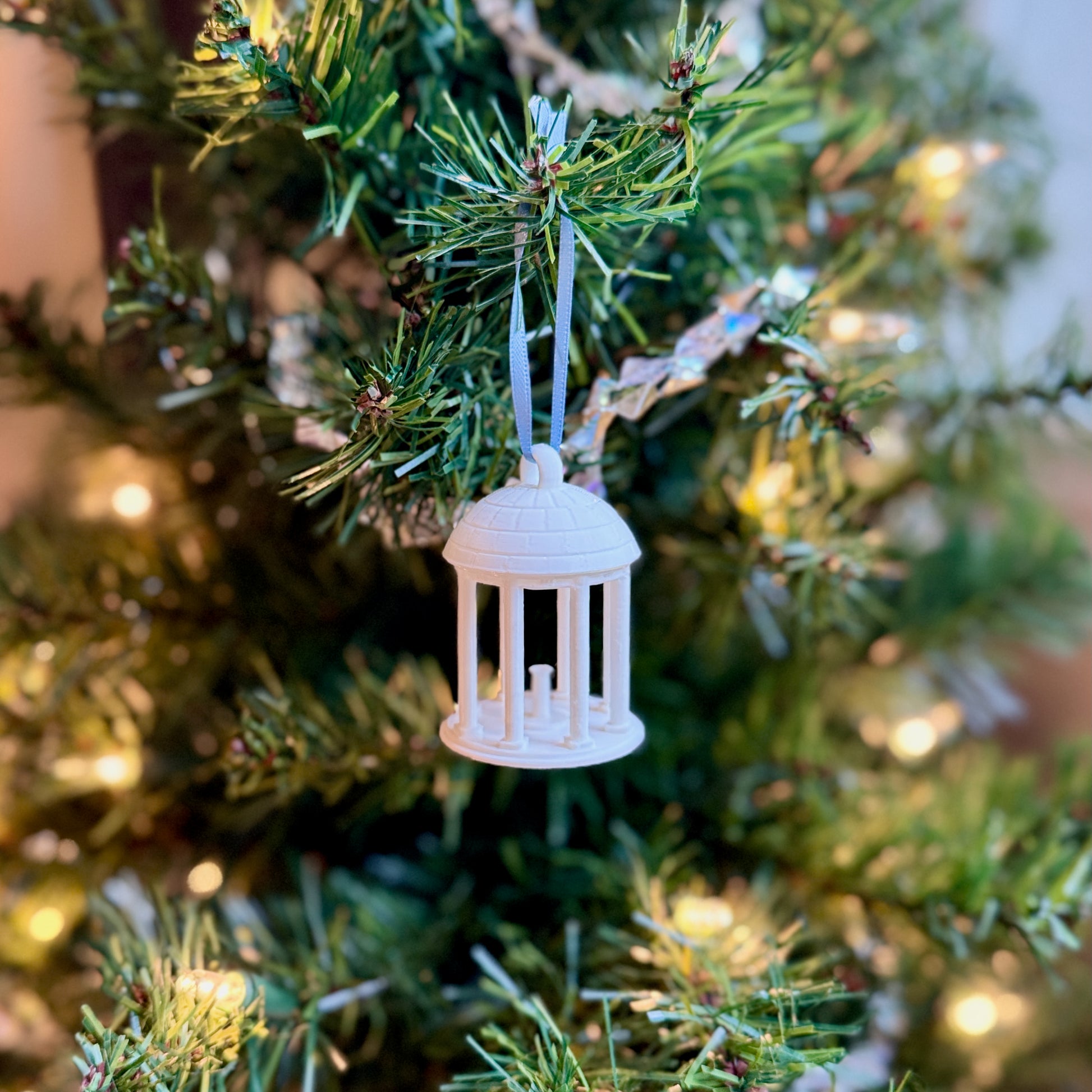 The UNC Old Well ornament shown on a UNC tree.