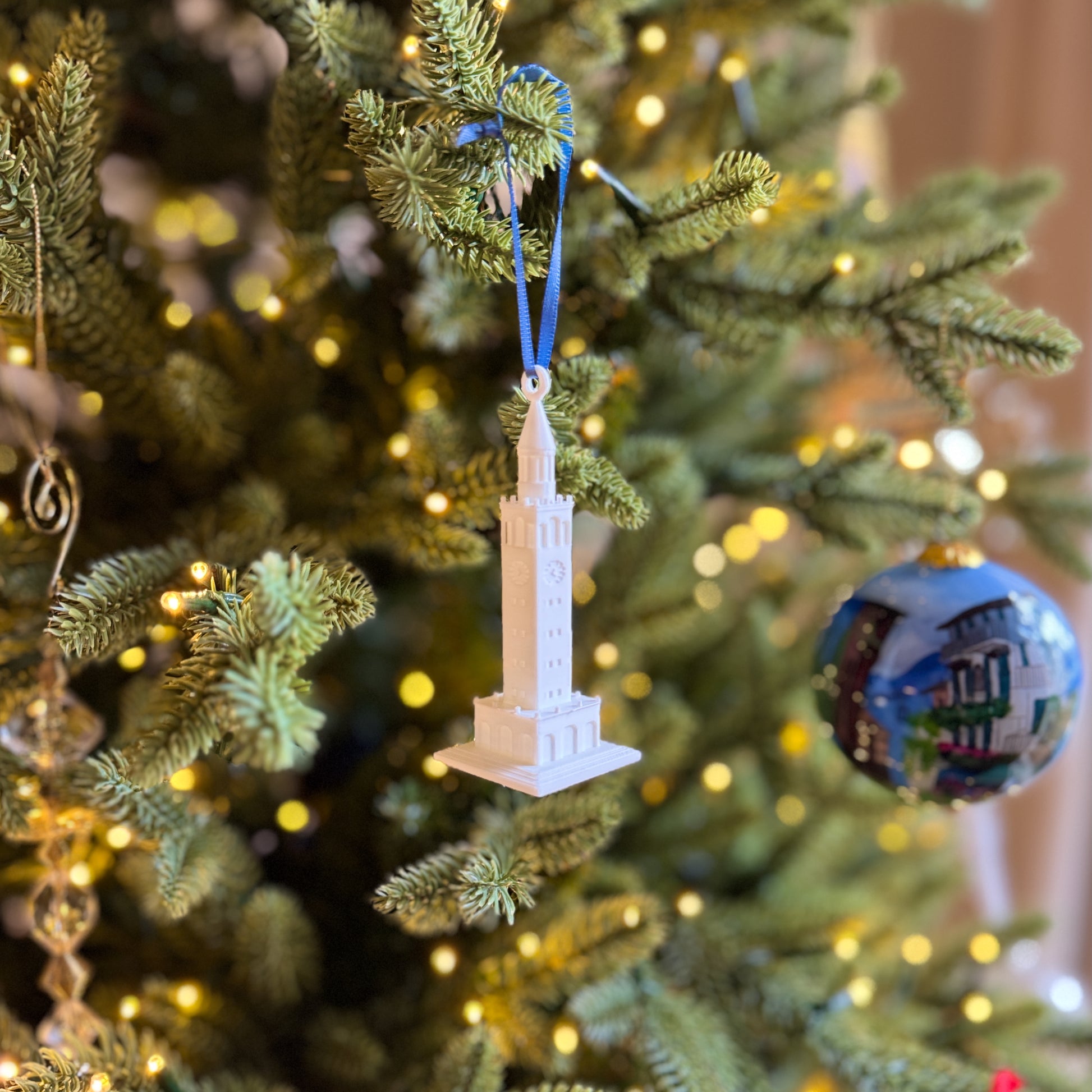 The UNC Bell Tower Christmas ornament, shown on a UNC tree.