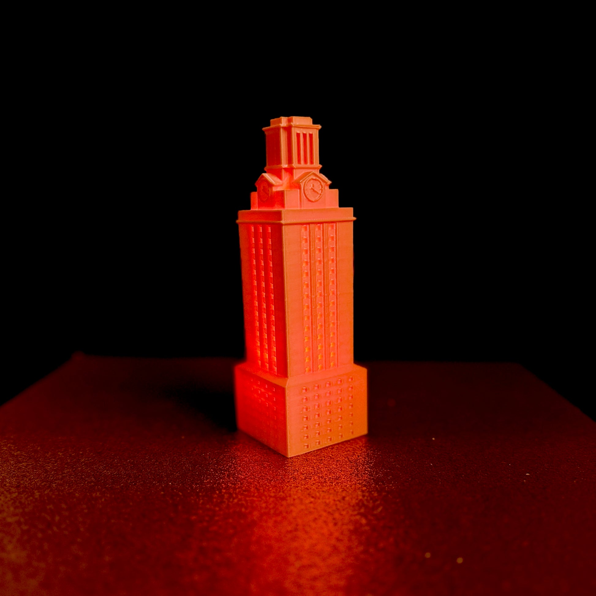 The Orange UT Tower light, shown against a black background.