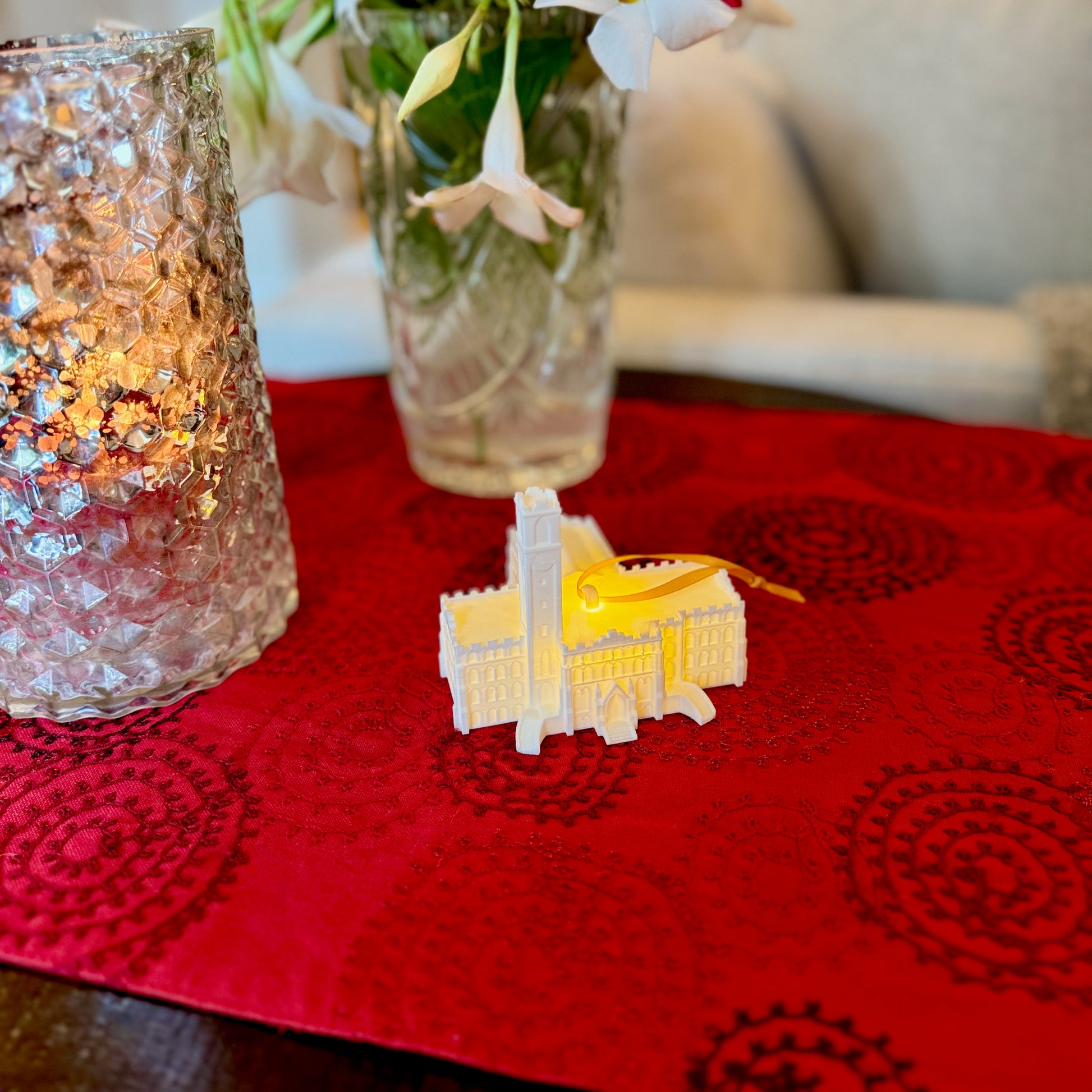 The Vanderbilt Kirkland Hall ornament with a light, shown in a home decorated for Christmas.