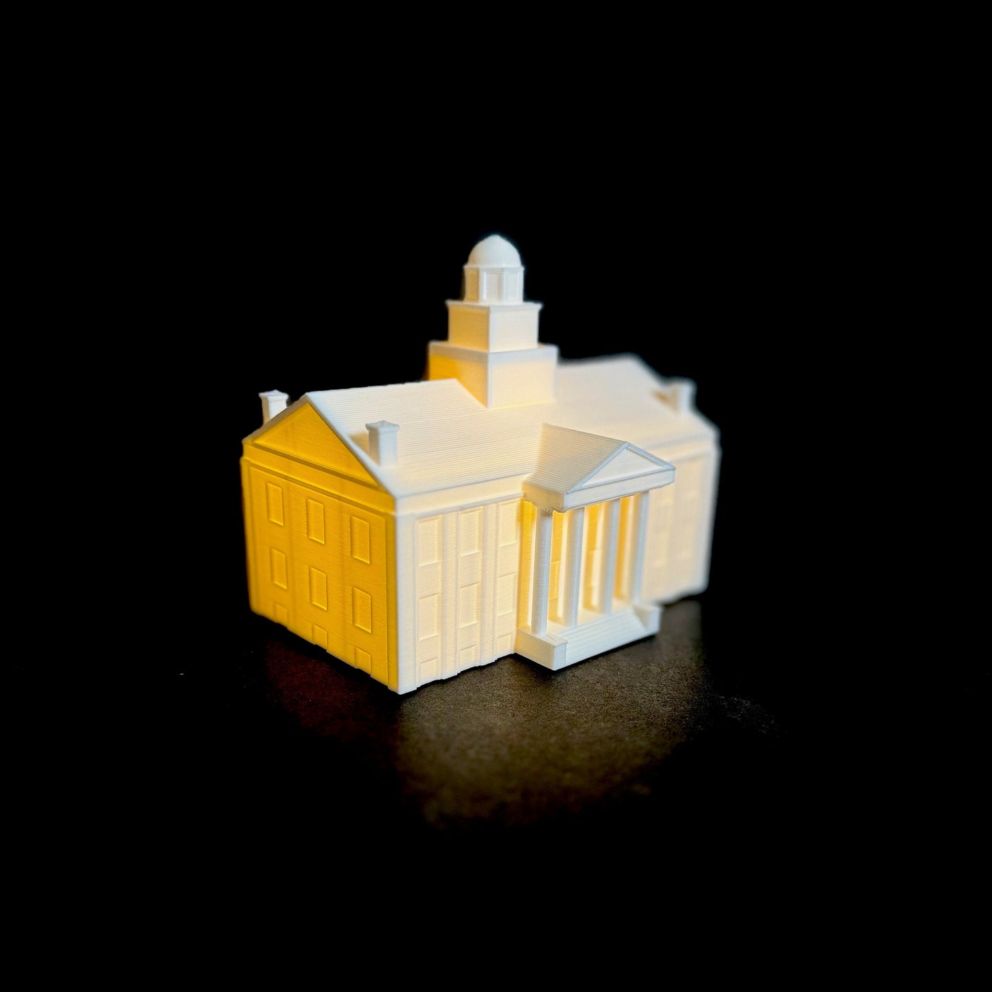 Side view of the lighted University of Iowa keepsake figurine, designed as a replica of the Iowa Old Main building.