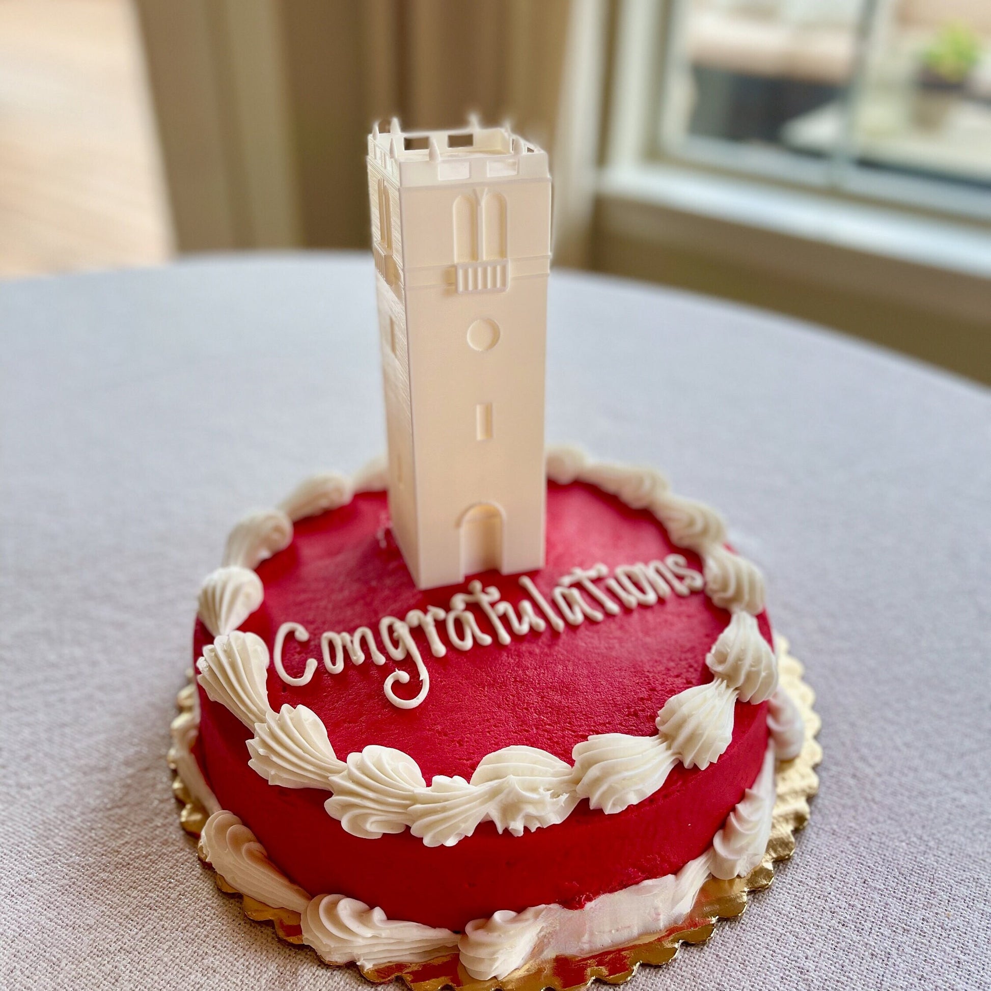 The University of Wisconsin cake topper, shown on a red Wisconsin graduation cake.