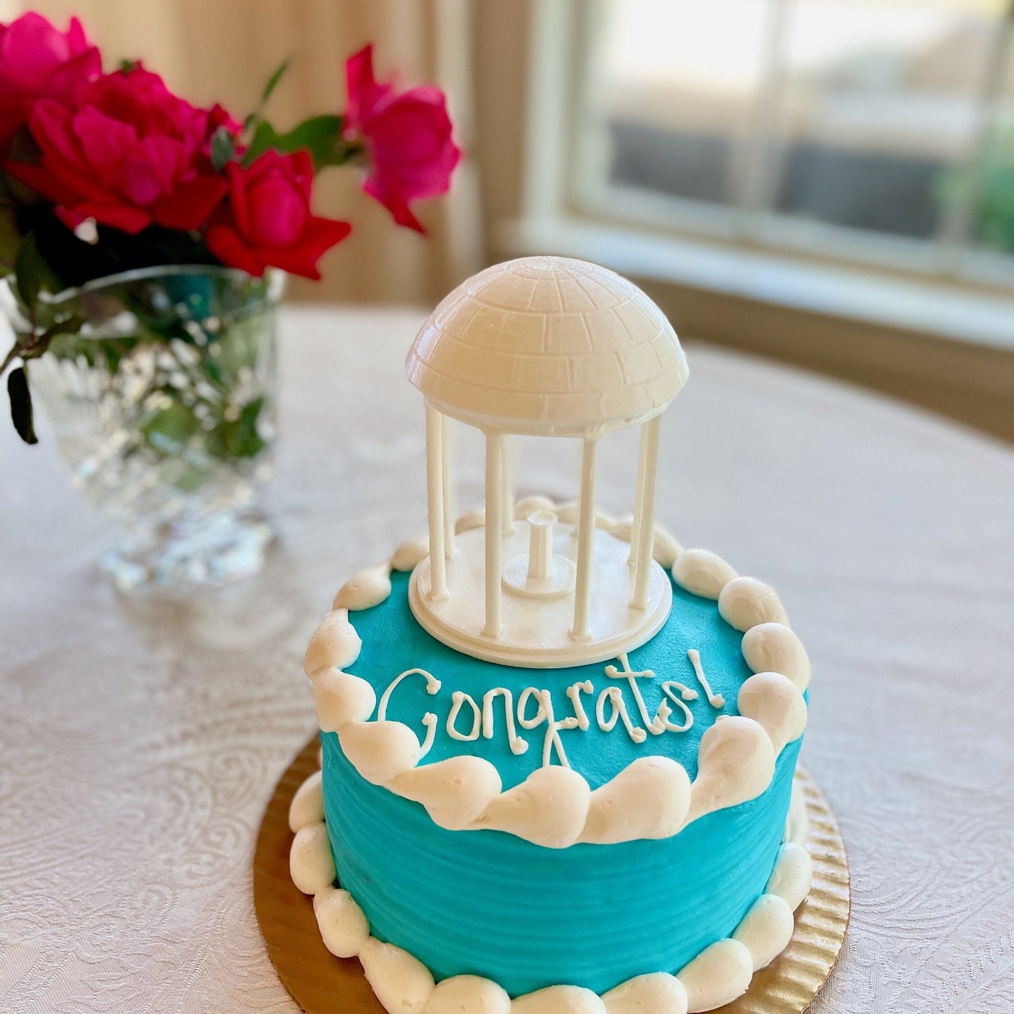 The UNC cake topper, designed as a replica of the UNC Old Well and shown on a graduation cake.