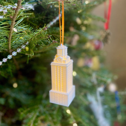 The lighted University of Texas ornament, shown on a Christmas tree and designed in honor of the UT Tower.