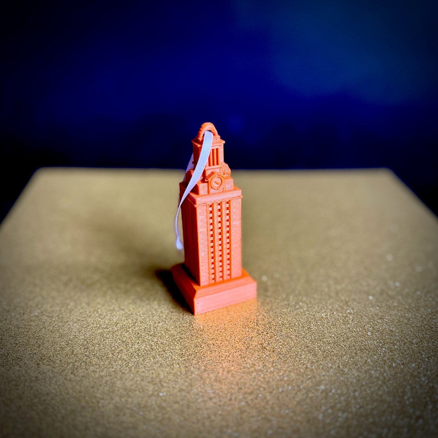 Spotlight photo of the burnt orange UT Tower ornament.